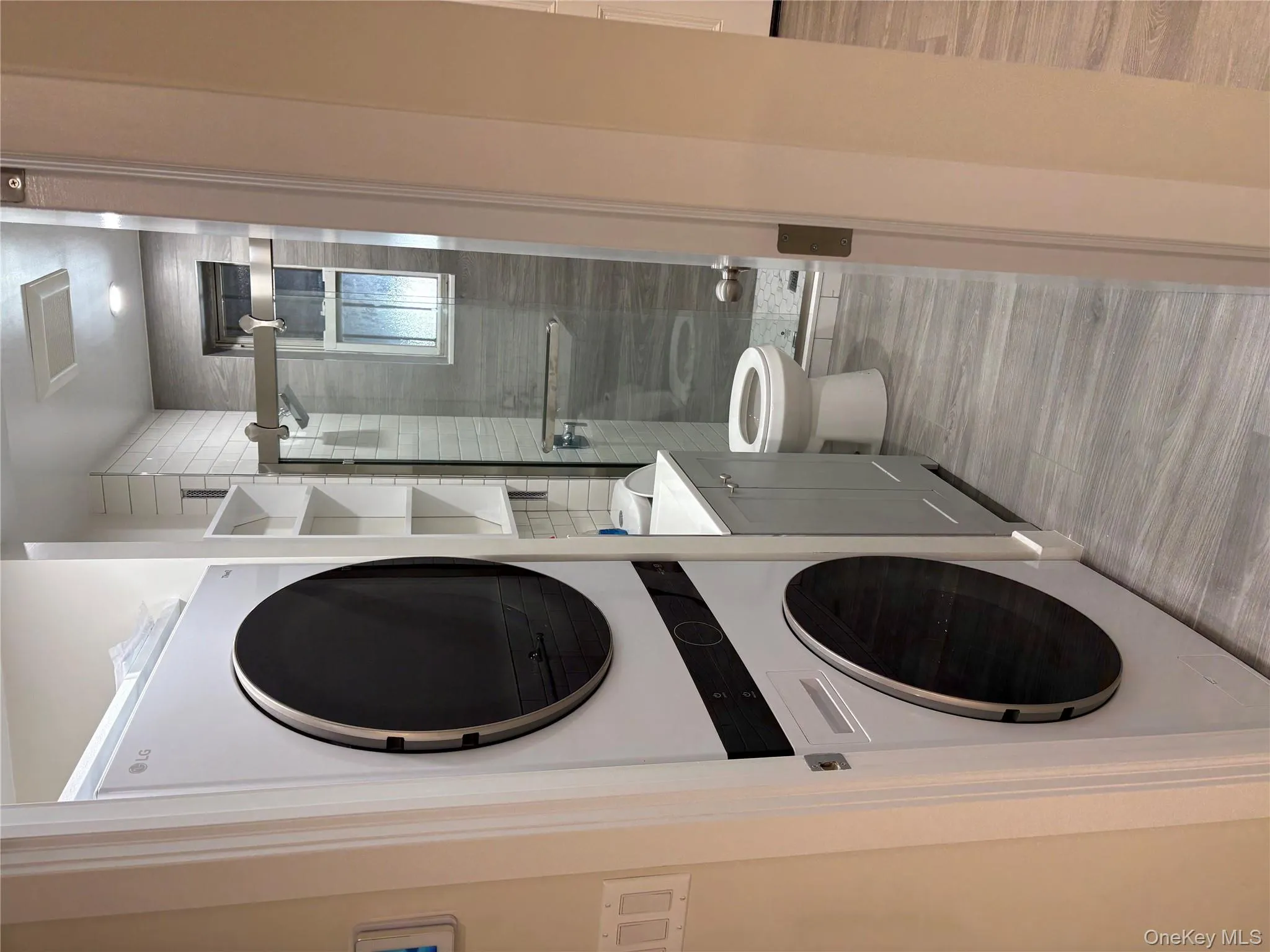 Full bathroom featuring a shower stall, estacked W/D and vanity Full bathroom featuring a shower stall, estacked W/D and vanity