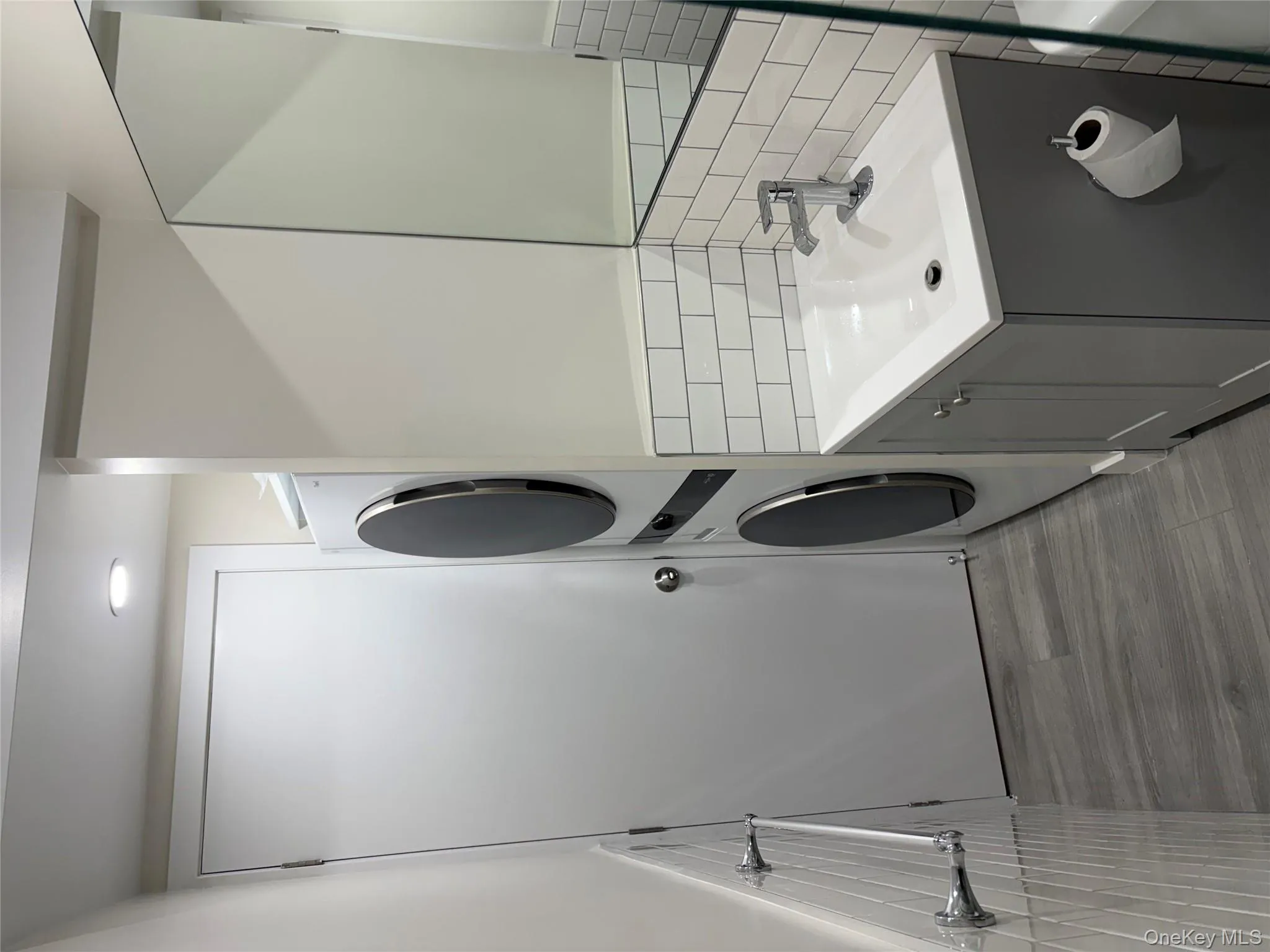 Bathroom with vanity, stacked W/D, & tile walls Bathroom with vanity, stacked W/D, & tile walls