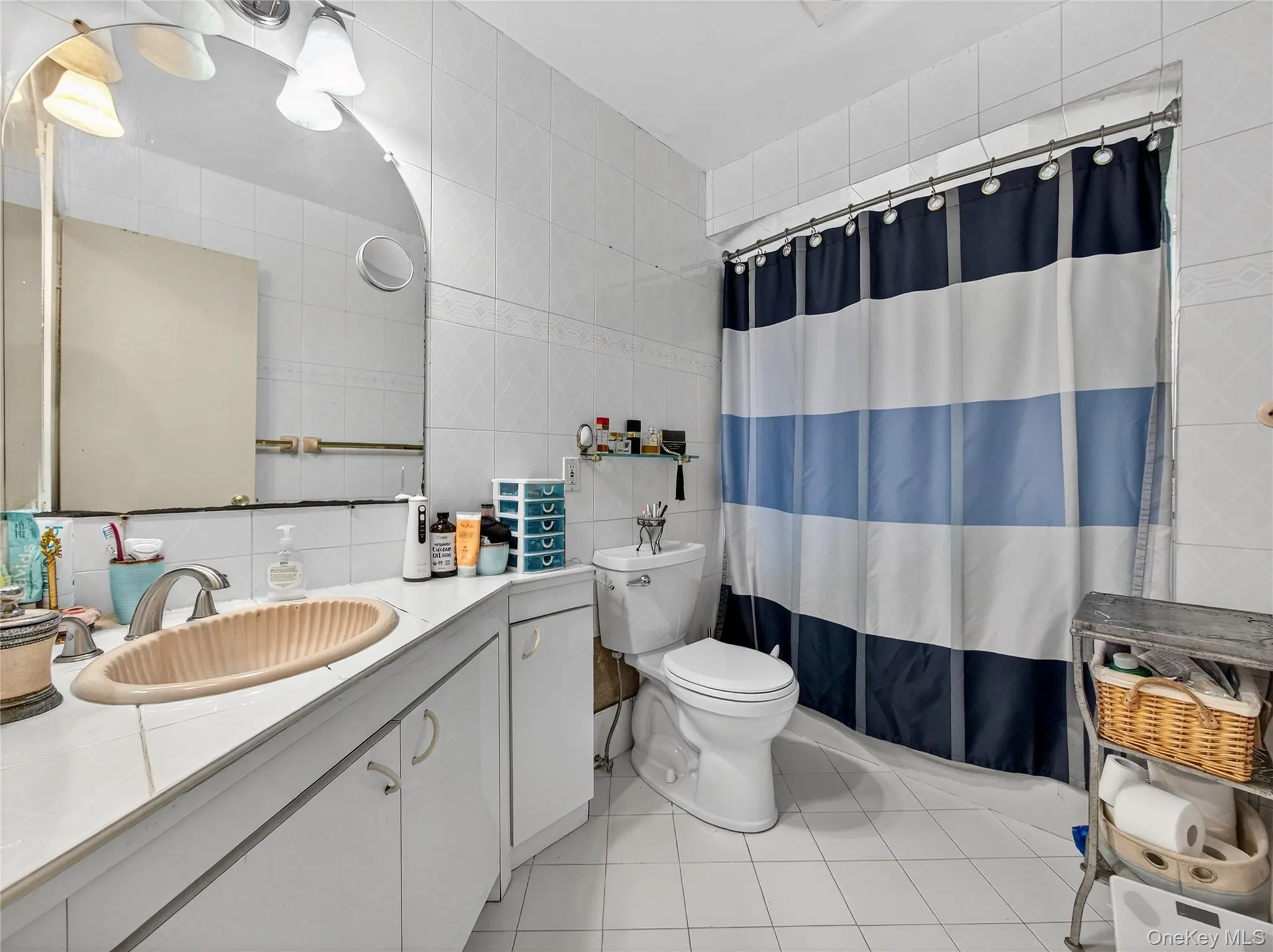 Bathroom featuring tile walls, vanity, light tile patterned floors, and tasteful backsplash Bathroom featuring tile walls, vanity, light tile patterned floors, and tasteful backsplash