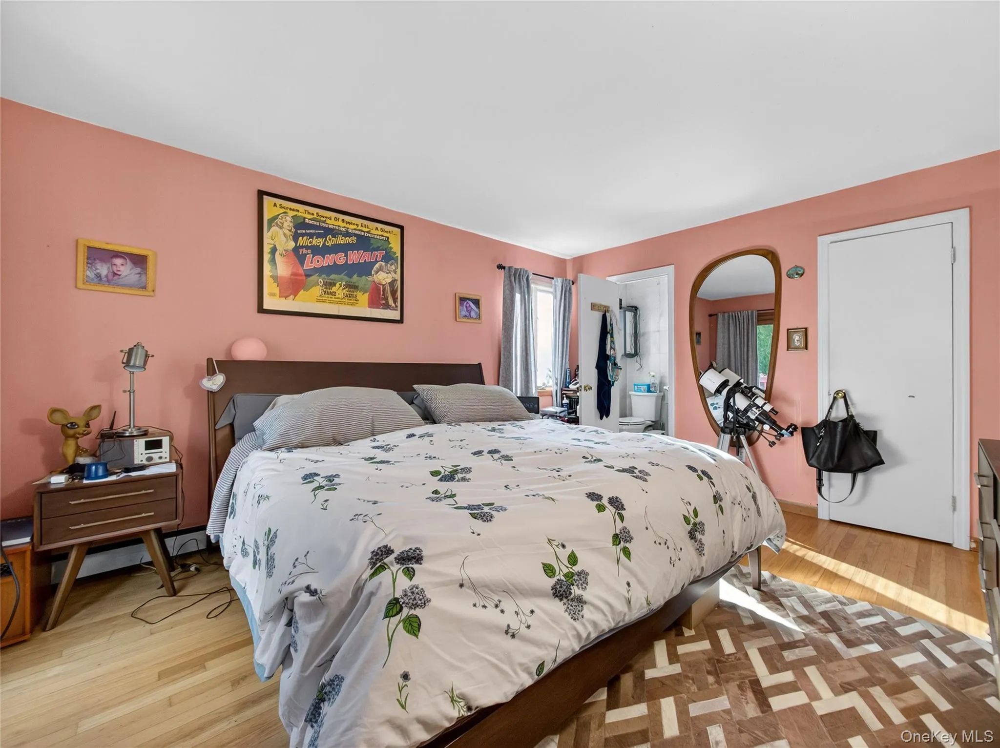 Bedroom featuring light wood-type flooring, ensuite bath, and baseboard heating Bedroom featuring light wood-type flooring, ensuite bath, and baseboard heating