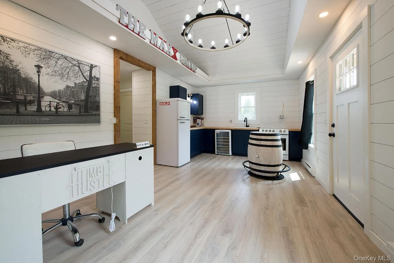 Unfurnished office featuring wooden walls, light wood-style flooring, wine cooler, recessed lighting, and a chandelier Unfurnished office featuring wooden walls, light wood-style flooring, wine cooler, recessed lighting, and a chandelier
