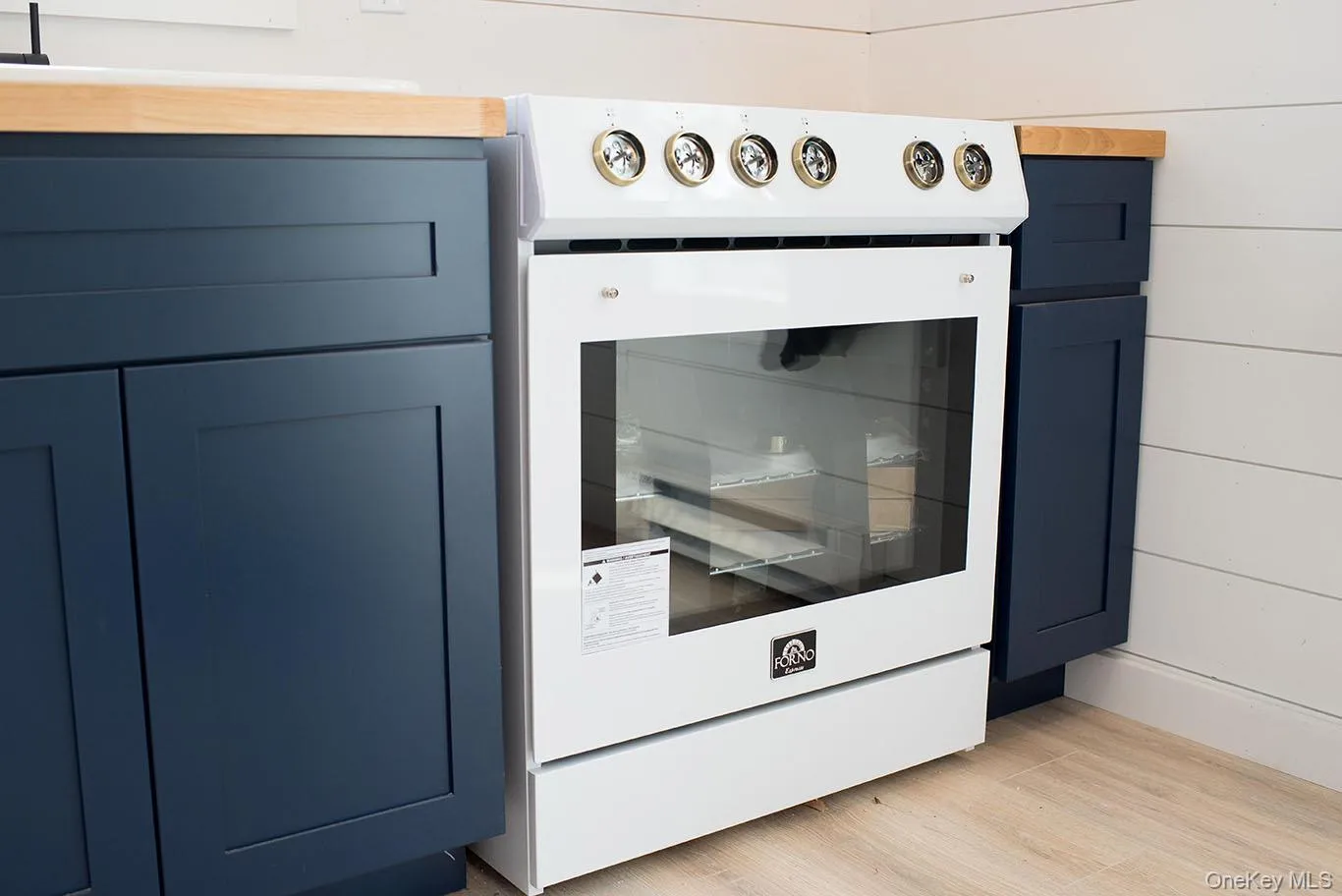 Kitchen view of blue cabinetry, high end white range oven, and wood finished floors Kitchen view of blue cabinetry, high end white range oven, and wood finished floors