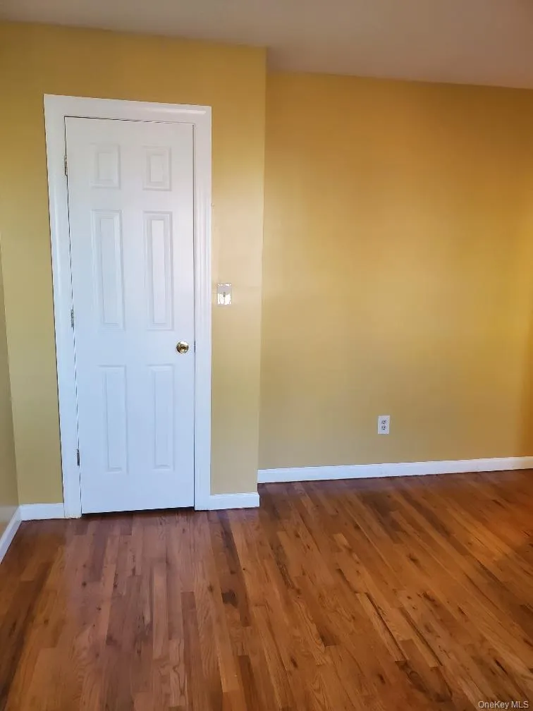 Empty room featuring baseboards and dark wood-style floors Empty room featuring baseboards and dark wood-style floors