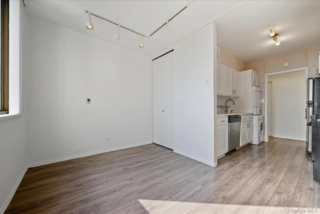 Kitchen with white cabinets, light countertops, light wood-type flooring, and appliances with stainless steel finishes Kitchen with white cabinets, light countertops, light wood-type flooring, and appliances with stainless steel finishes
