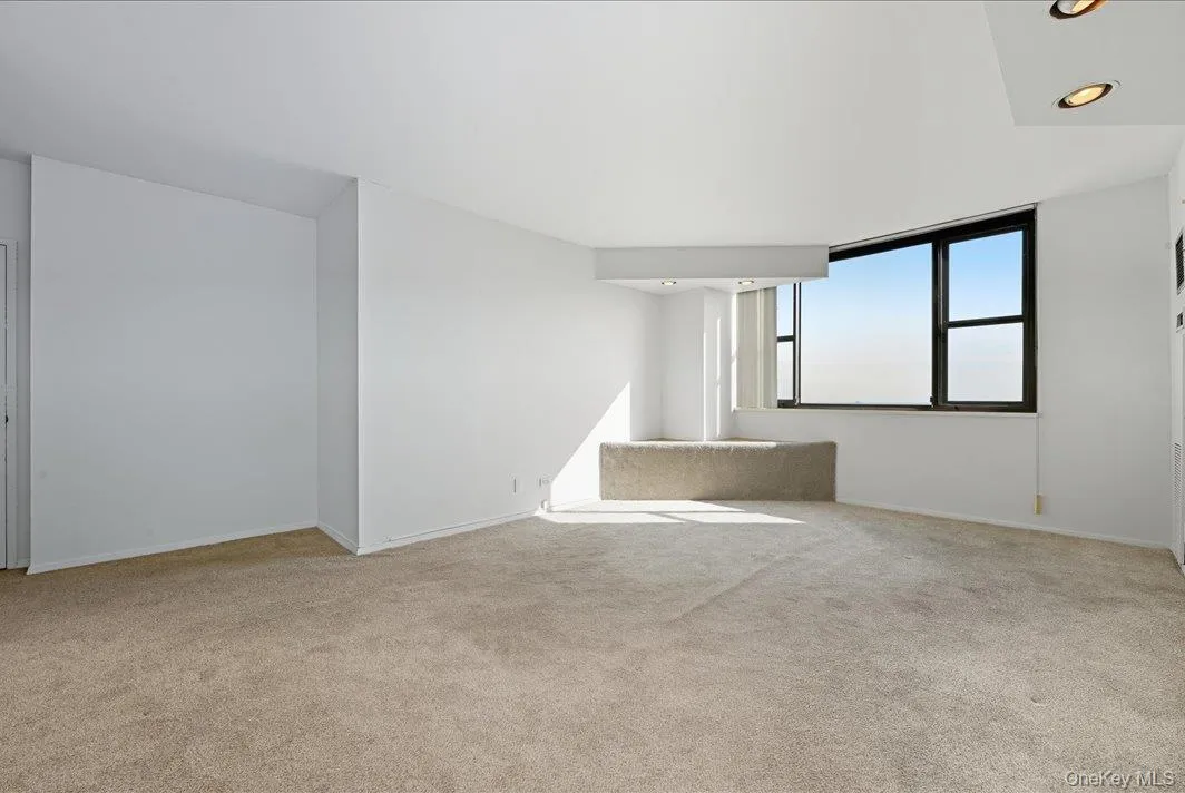 Empty room featuring recessed lighting and light colored carpet Empty room featuring recessed lighting and light colored carpet