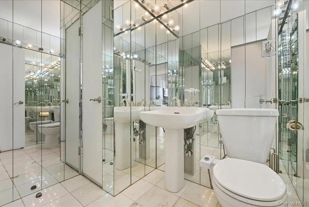 Bathroom featuring tile walls, tile patterned flooring, and a chandelier Bathroom featuring tile walls, tile patterned flooring, and a chandelier