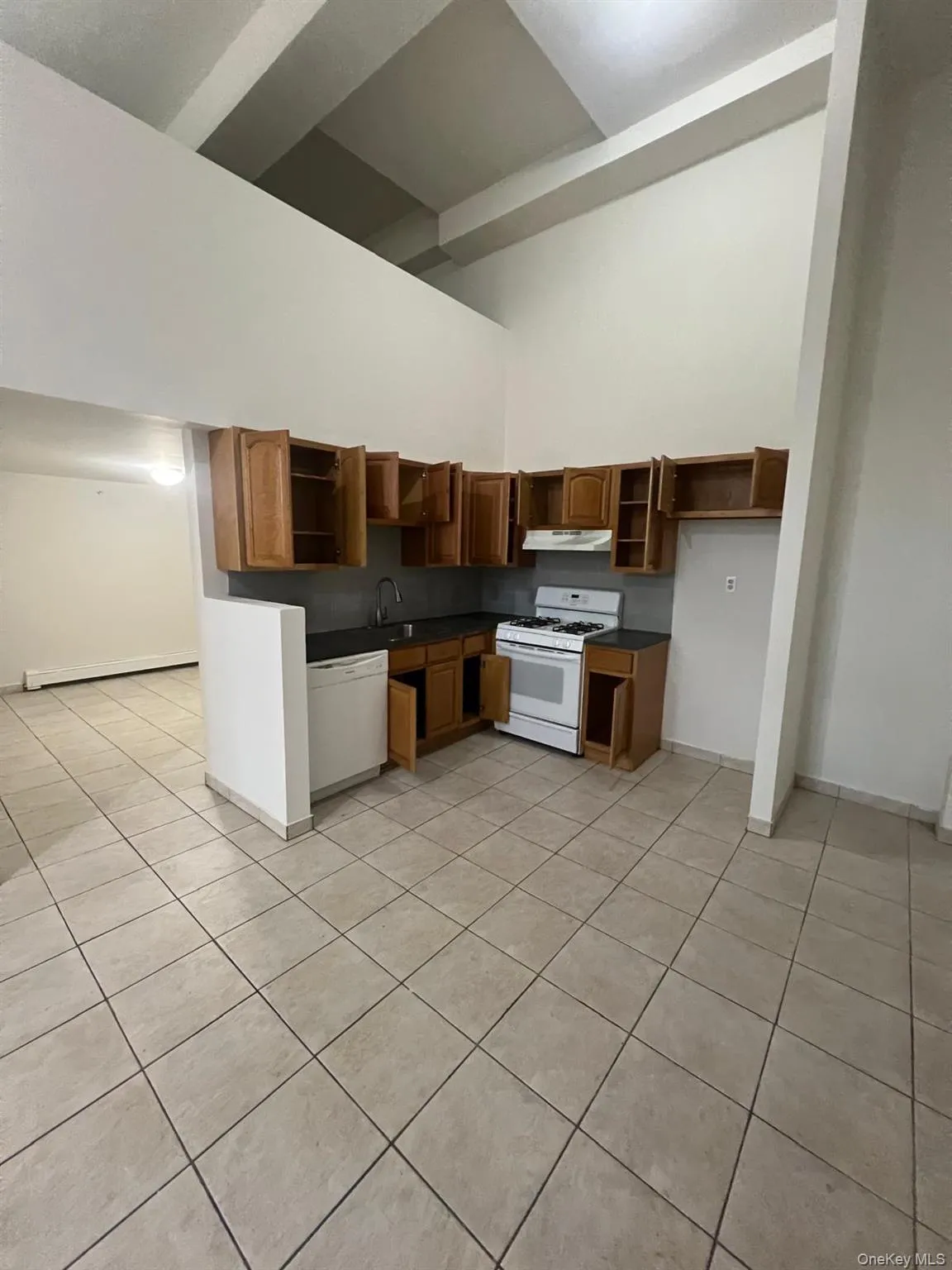 Kitchen with dark countertops, open shelves, light tile patterned flooring, white appliances, and baseboard heating Kitchen with dark countertops, open shelves, light tile patterned flooring, white appliances, and baseboard heating