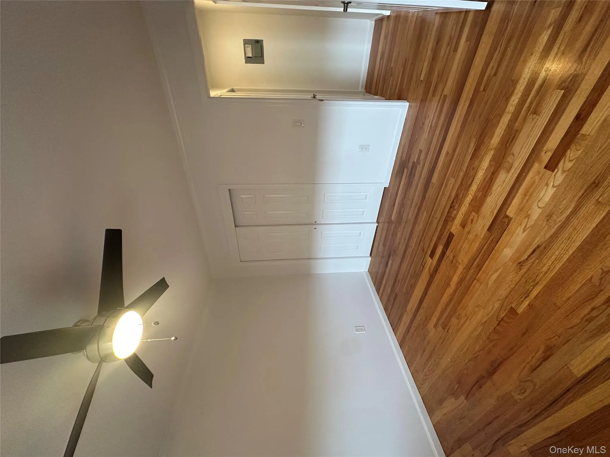 Unfurnished bedroom featuring dark wood-style flooring, a closet, and a ceiling fan Unfurnished bedroom featuring dark wood-style flooring, a closet, and a ceiling fan