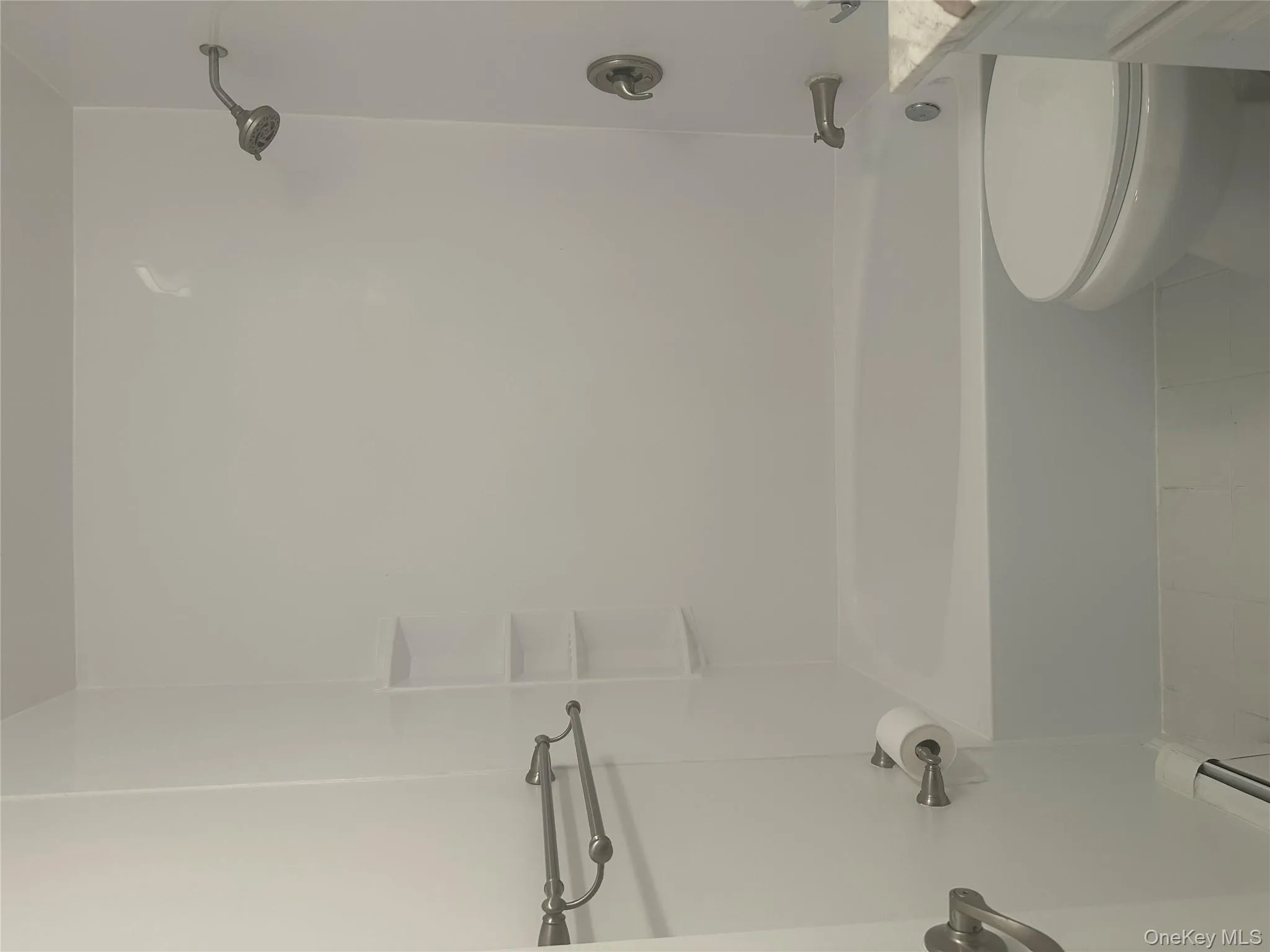 Bathroom with washtub / shower combination, tile patterned floors, vanity, and a baseboard heating unit Bathroom with washtub / shower combination, tile patterned floors, vanity, and a baseboard heating unit