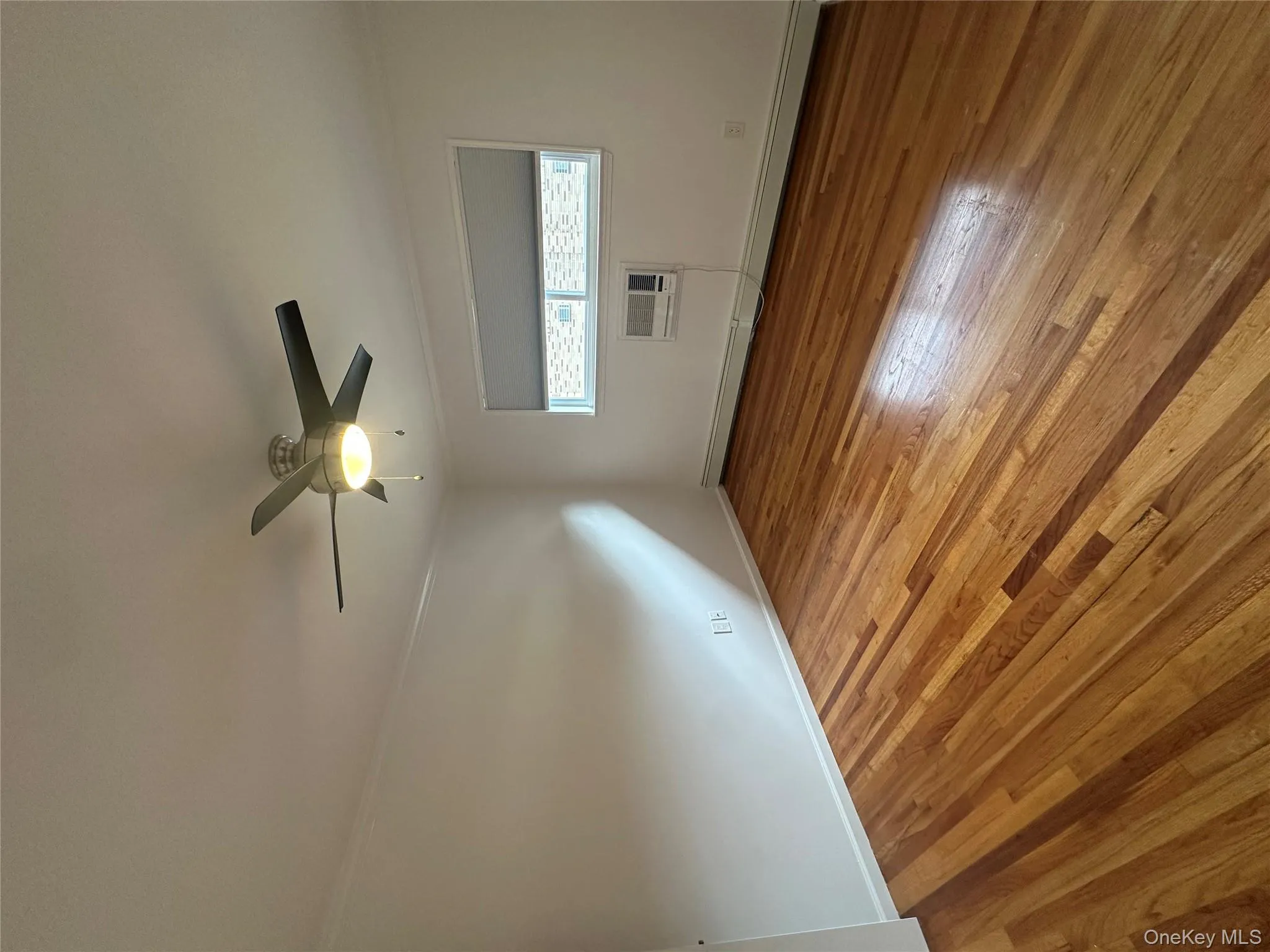 Unfurnished room featuring a baseboard heating unit, hardwood / wood-style flooring, ornamental molding, and ceiling fan Unfurnished room featuring a baseboard heating unit, hardwood / wood-style flooring, ornamental molding, and ceiling fan