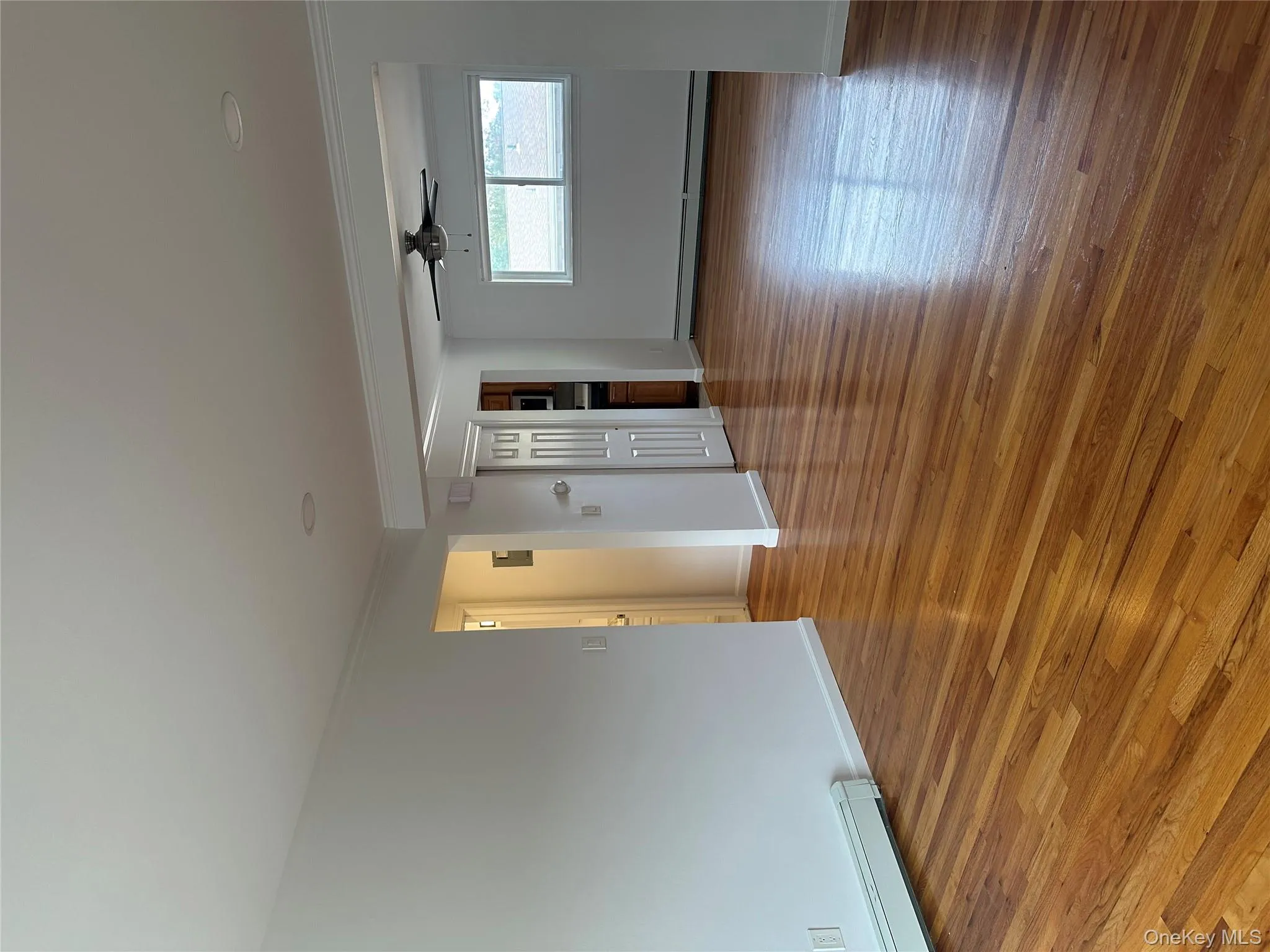 Unfurnished room featuring wood finished floors, crown molding, baseboard heating, and a ceiling fan Unfurnished room featuring wood finished floors, crown molding, baseboard heating, and a ceiling fan