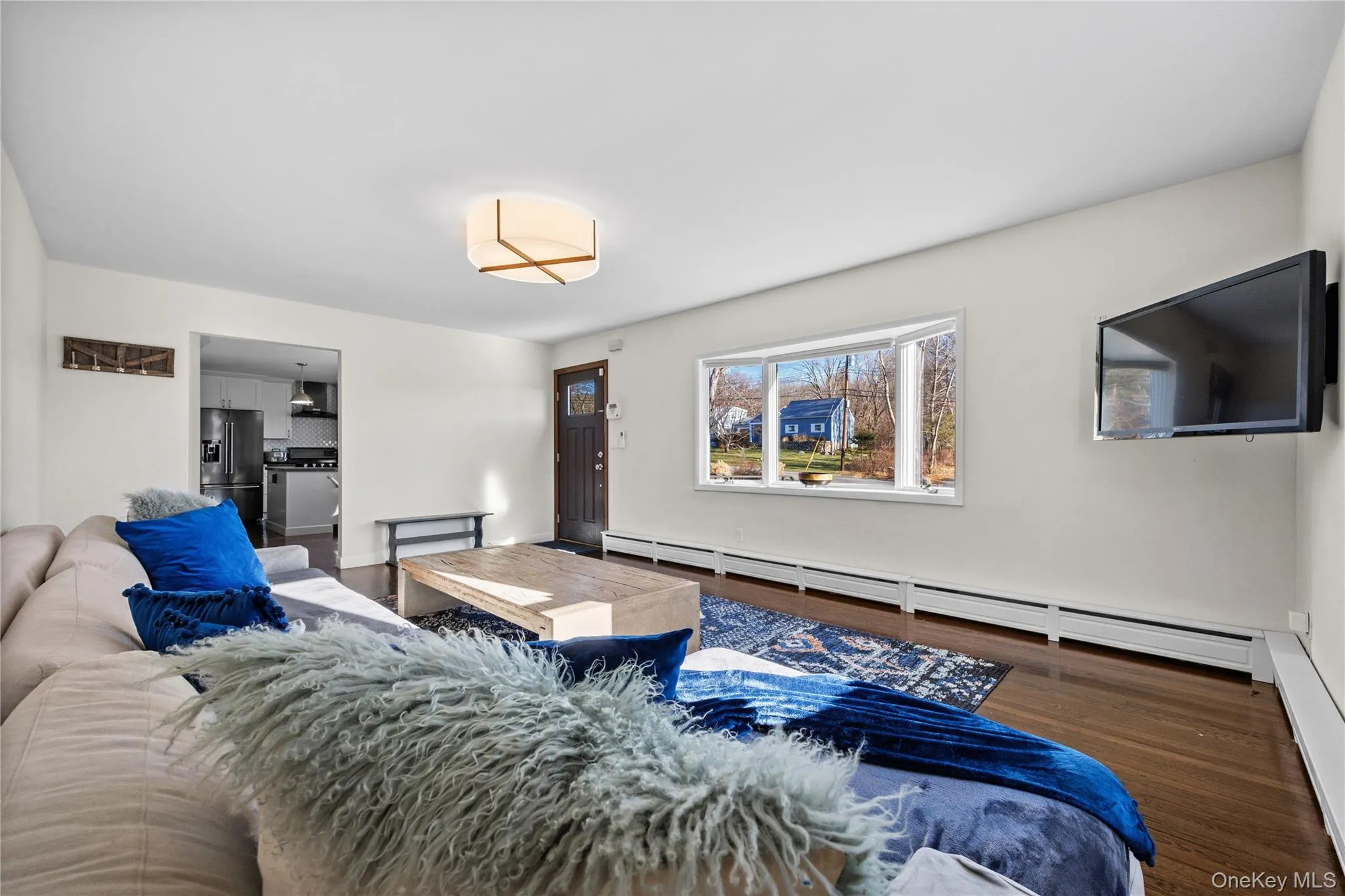 Living room featuring a baseboard heating unit, wood finished floors, and a baseboard radiator Living room featuring a baseboard heating unit, wood finished floors, and a baseboard radiator