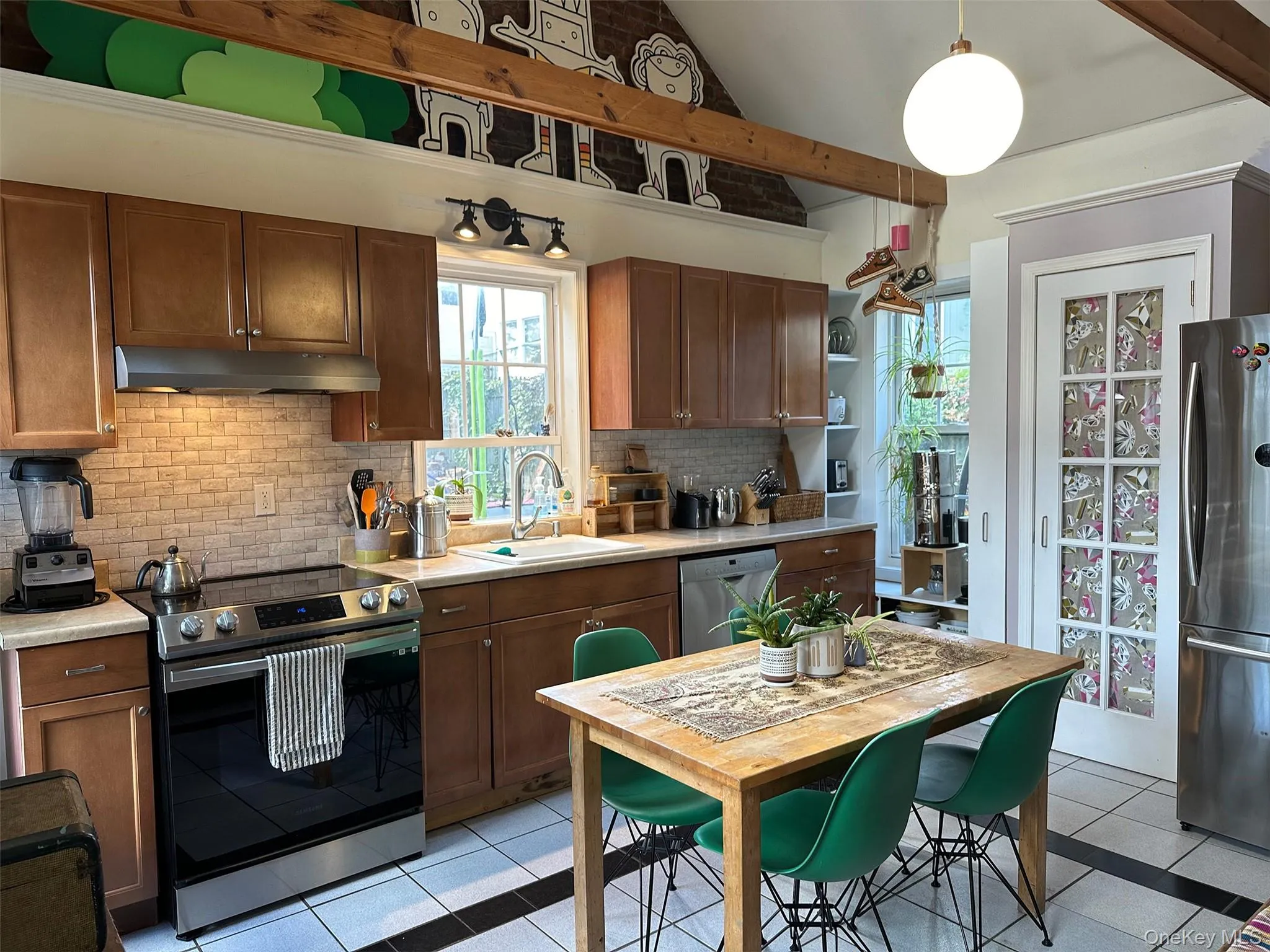 Kitchen with stainless steel appliances, pendant lighting, tasteful backsplash, light countertops, and brown cabinets Kitchen with stainless steel appliances, pendant lighting, tasteful backsplash, light countertops, and brown cabinets