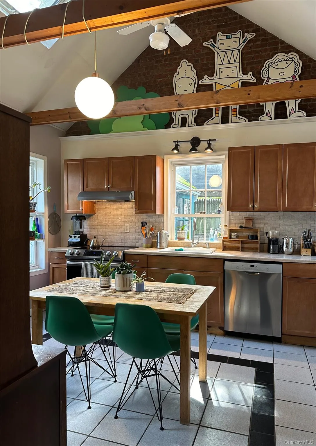 Kitchen with brown cabinets, backsplash, appliances with stainless steel finishes, beamed ceiling, and high vaulted ceiling Kitchen with brown cabinets, backsplash, appliances with stainless steel finishes, beamed ceiling, and high vaulted ceiling