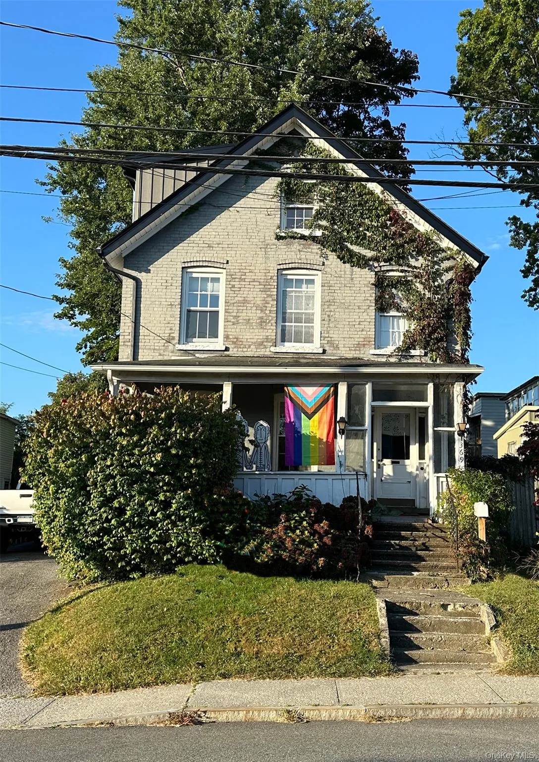 View of front of property featuring a porch, brick siding, and a front yard View of front of property featuring a porch, brick siding, and a front yard
