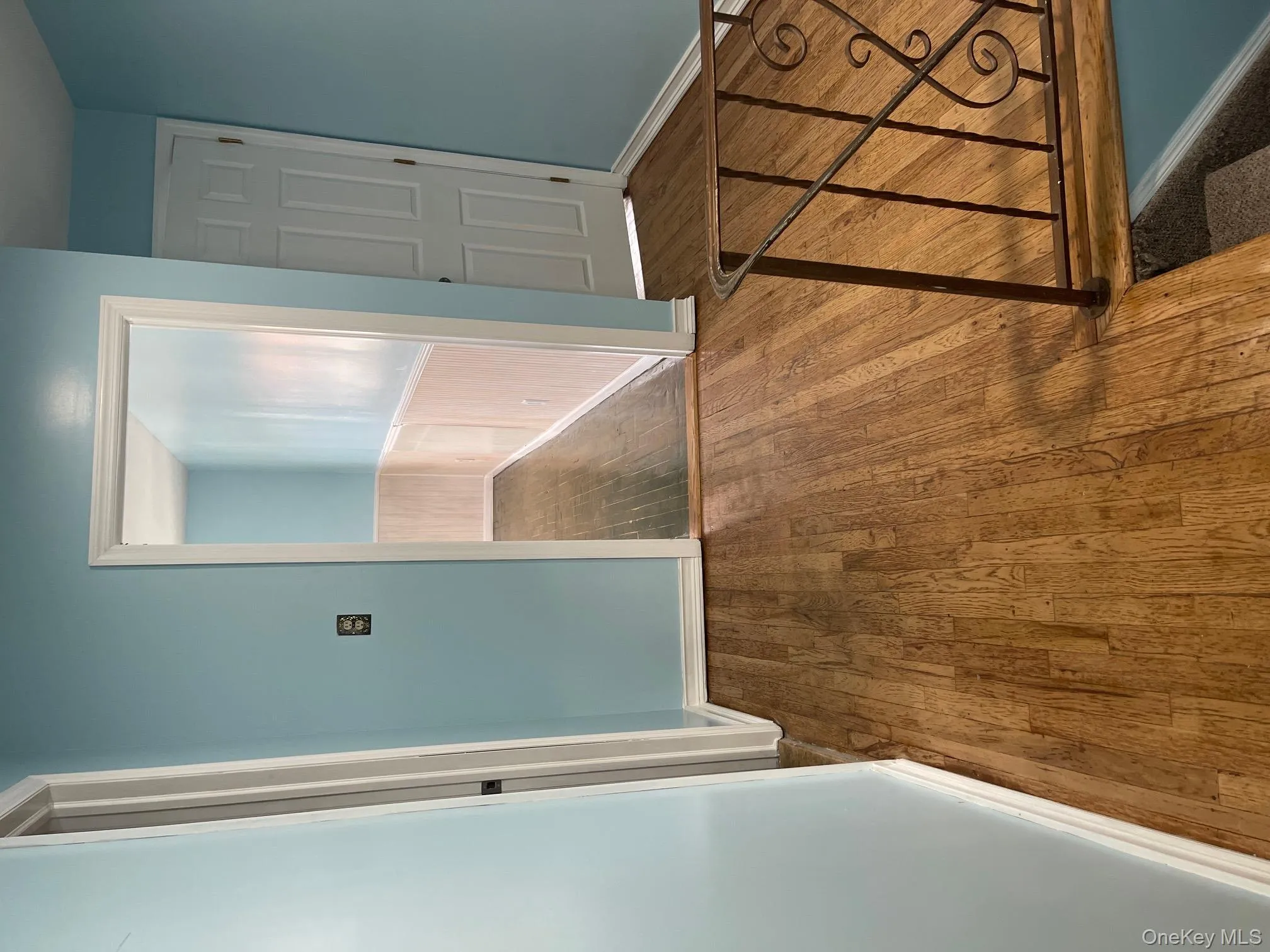 Hallway featuring dark wood-style flooring and a wainscoted wall Hallway featuring dark wood-style flooring and a wainscoted wall