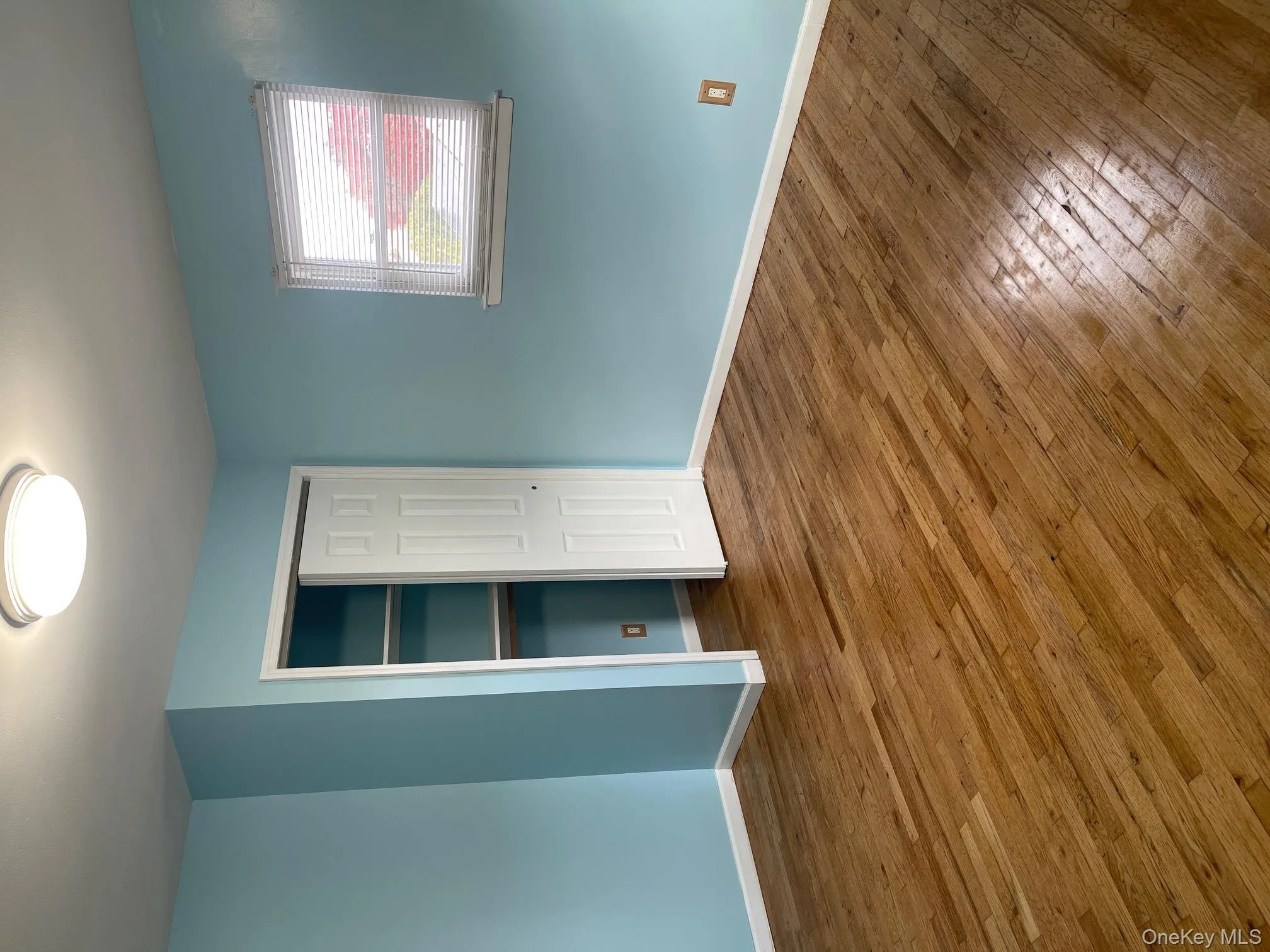 Unfurnished bedroom with wood-type flooring and a closet Unfurnished bedroom with wood-type flooring and a closet