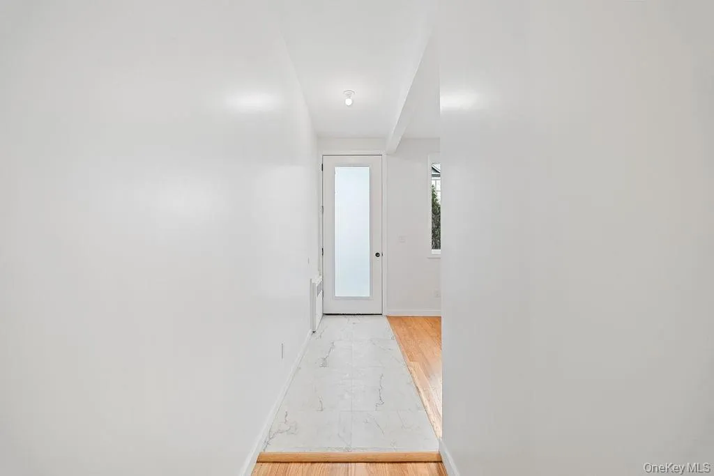 Hallway featuring light wood-type flooring and baseboards Hallway featuring light wood-type flooring and baseboards
