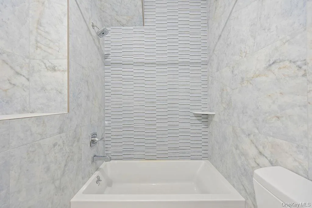 Full bath with shower / bathtub combination and tile walls Full bath with shower / bathtub combination and tile walls