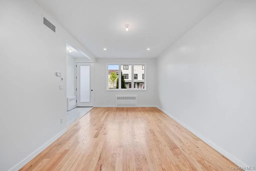 Spare room featuring light wood-type flooring, radiator, and recessed lighting Spare room featuring light wood-type flooring, radiator, and recessed lighting