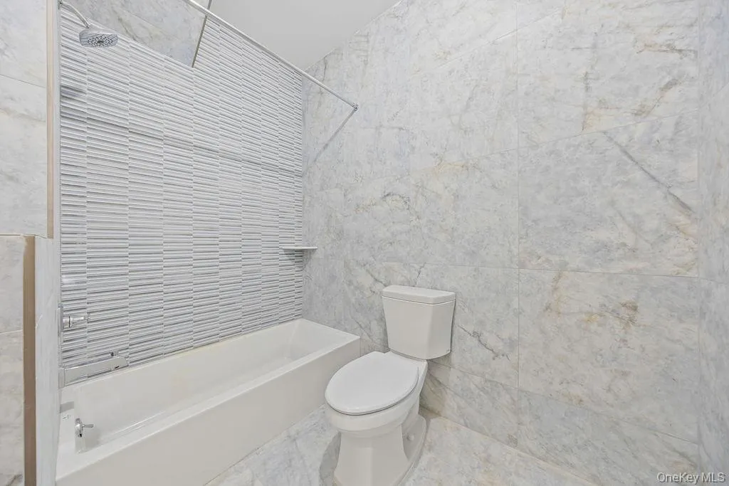 Full bathroom with tile walls and shower combination Full bathroom with tile walls and shower combination