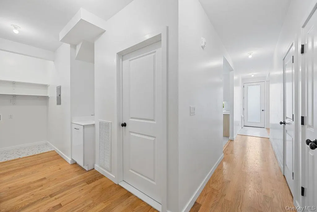 Corridor featuring light wood finished floors and baseboards Corridor featuring light wood finished floors and baseboards
