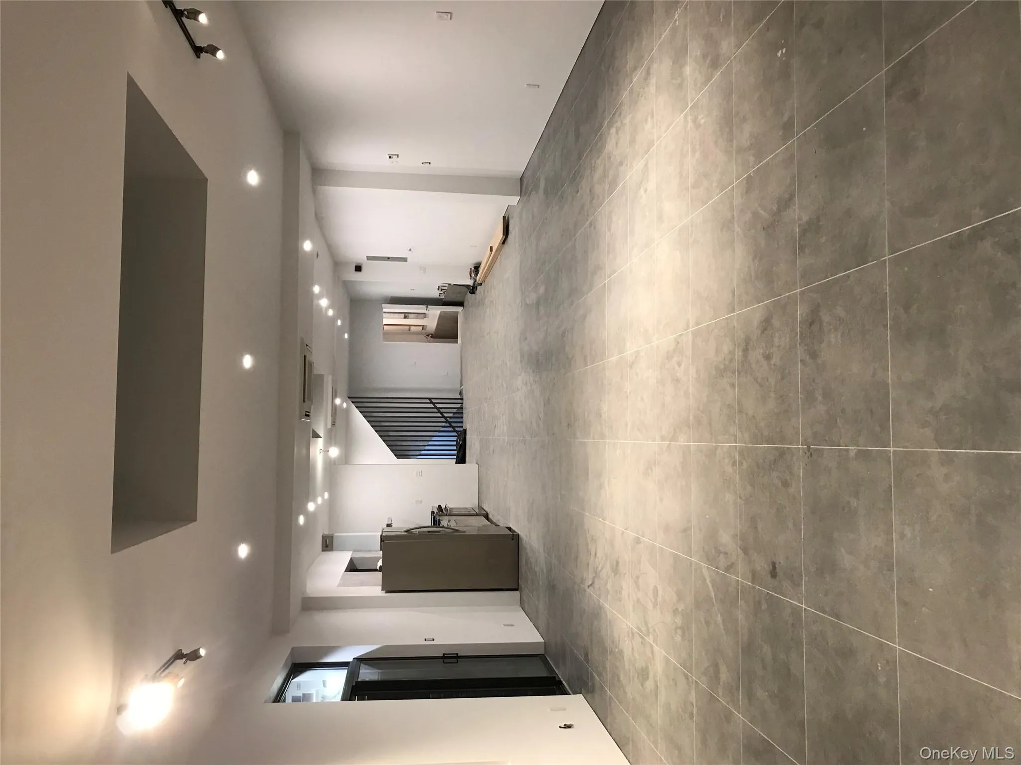 Basement with rail lighting, fridge, light tile patterned floors, and recessed lighting Basement with rail lighting, fridge, light tile patterned floors, and recessed lighting