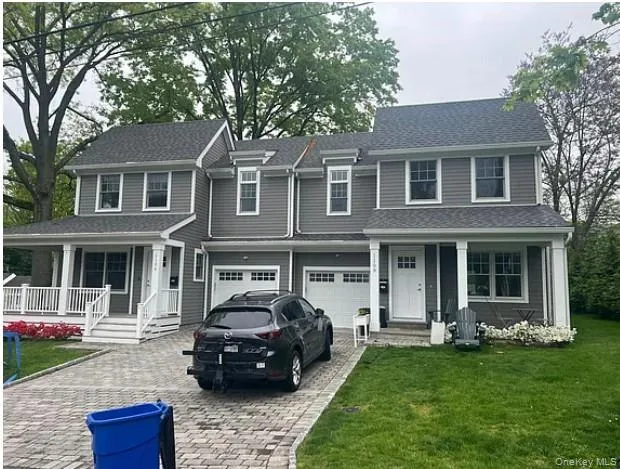 View of front of property with a porch, decorative driveway, a front yard, a garage, and a shingled roof View of front of property with a porch, decorative driveway, a front yard, a garage, and a shingled roof