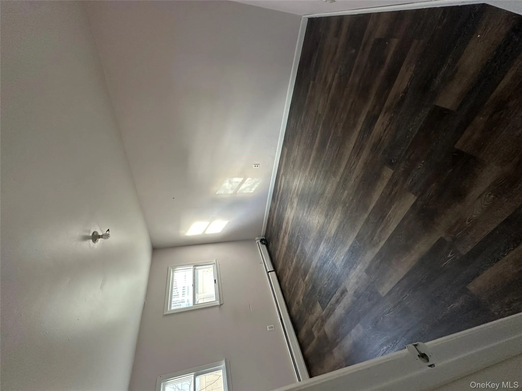 Unfurnished room with dark wood-style floors and baseboard heating Unfurnished room with dark wood-style floors and baseboard heating