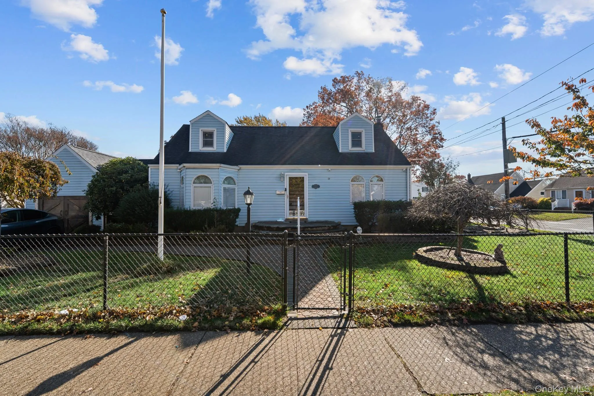 Cape cod home featuring a gate and a fenced front yard Cape cod home featuring a gate and a fenced front yard