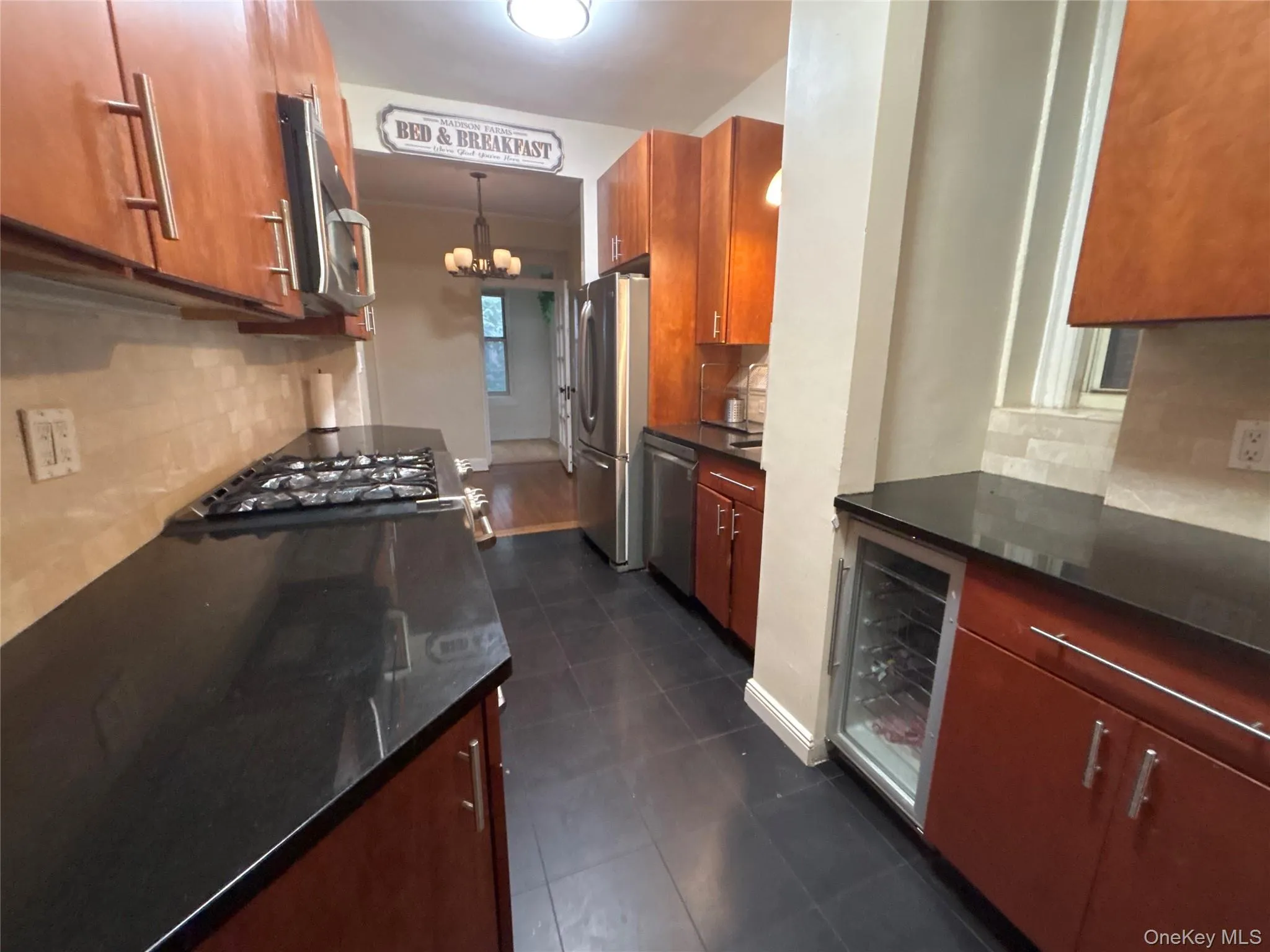 Kitchen with tasteful backsplash, beverage cooler, and brown cabinets Kitchen with tasteful backsplash, beverage cooler, and brown cabinets
