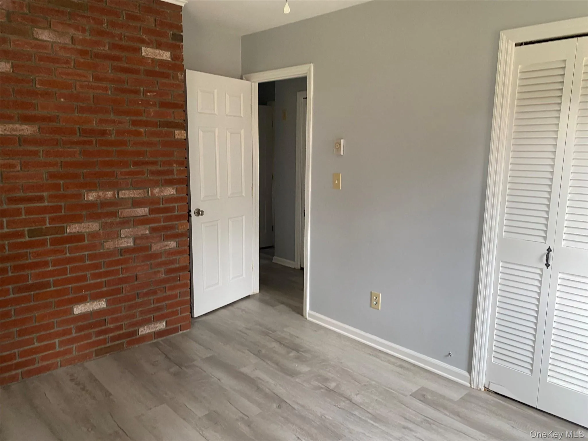 Bedroom with brick feature wall and a closet Bedroom with brick feature wall and a closet
