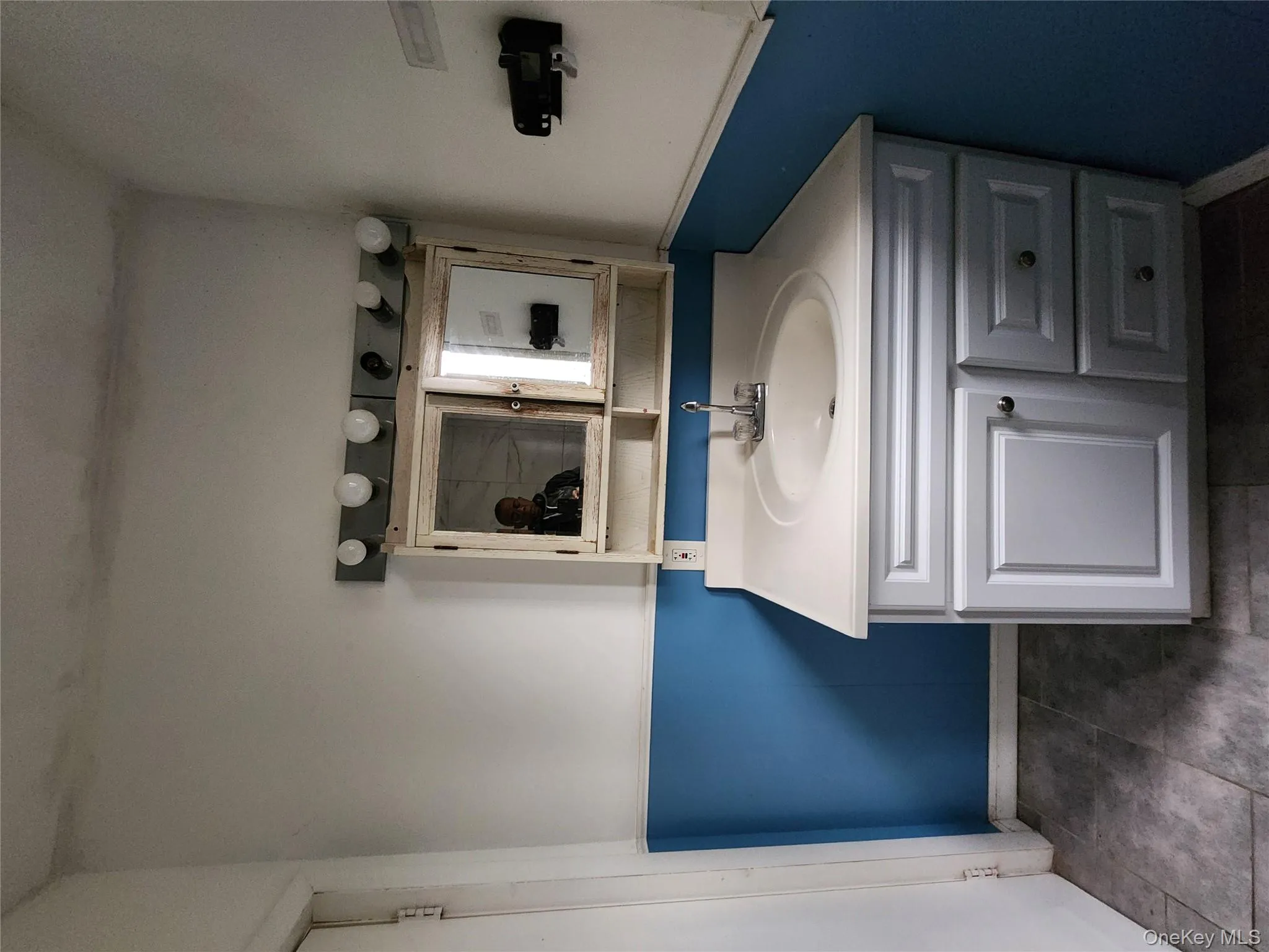 Bathroom featuring vanity and dark tile patterned floors Bathroom featuring vanity and dark tile patterned floors