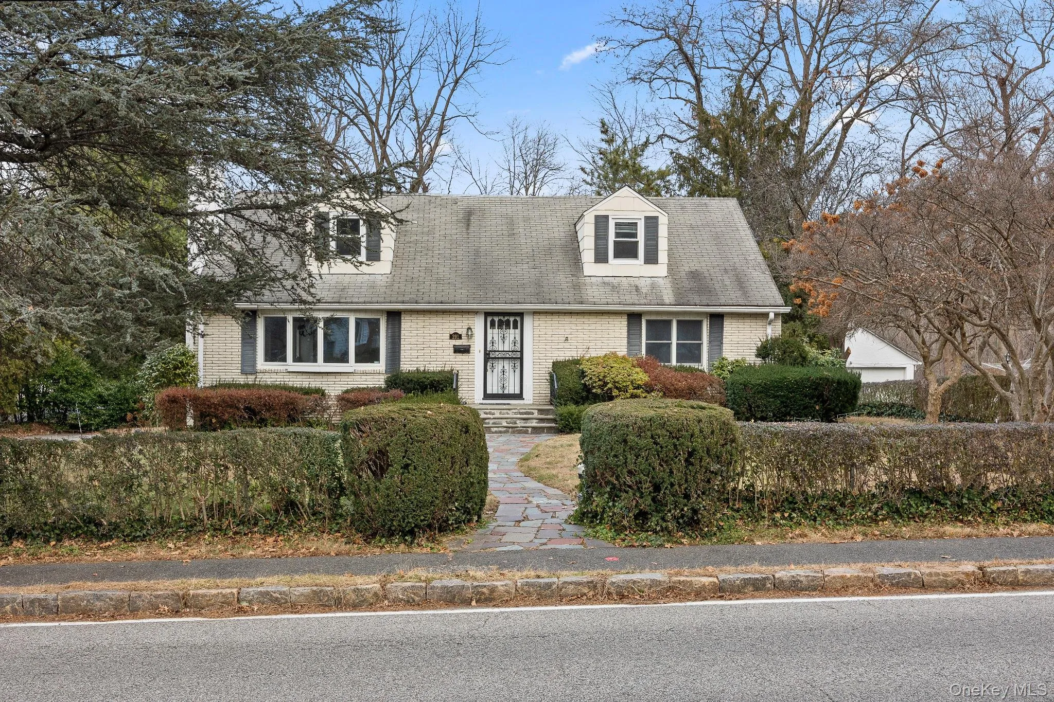 Cape cod house with brick siding and a shingled roof Cape cod house with brick siding and a shingled roof
