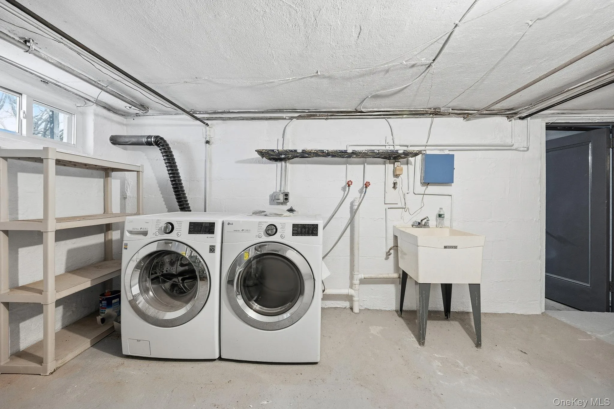 Washroom with concrete floors and washing machine and clothes dryer Washroom with concrete floors and washing machine and clothes dryer