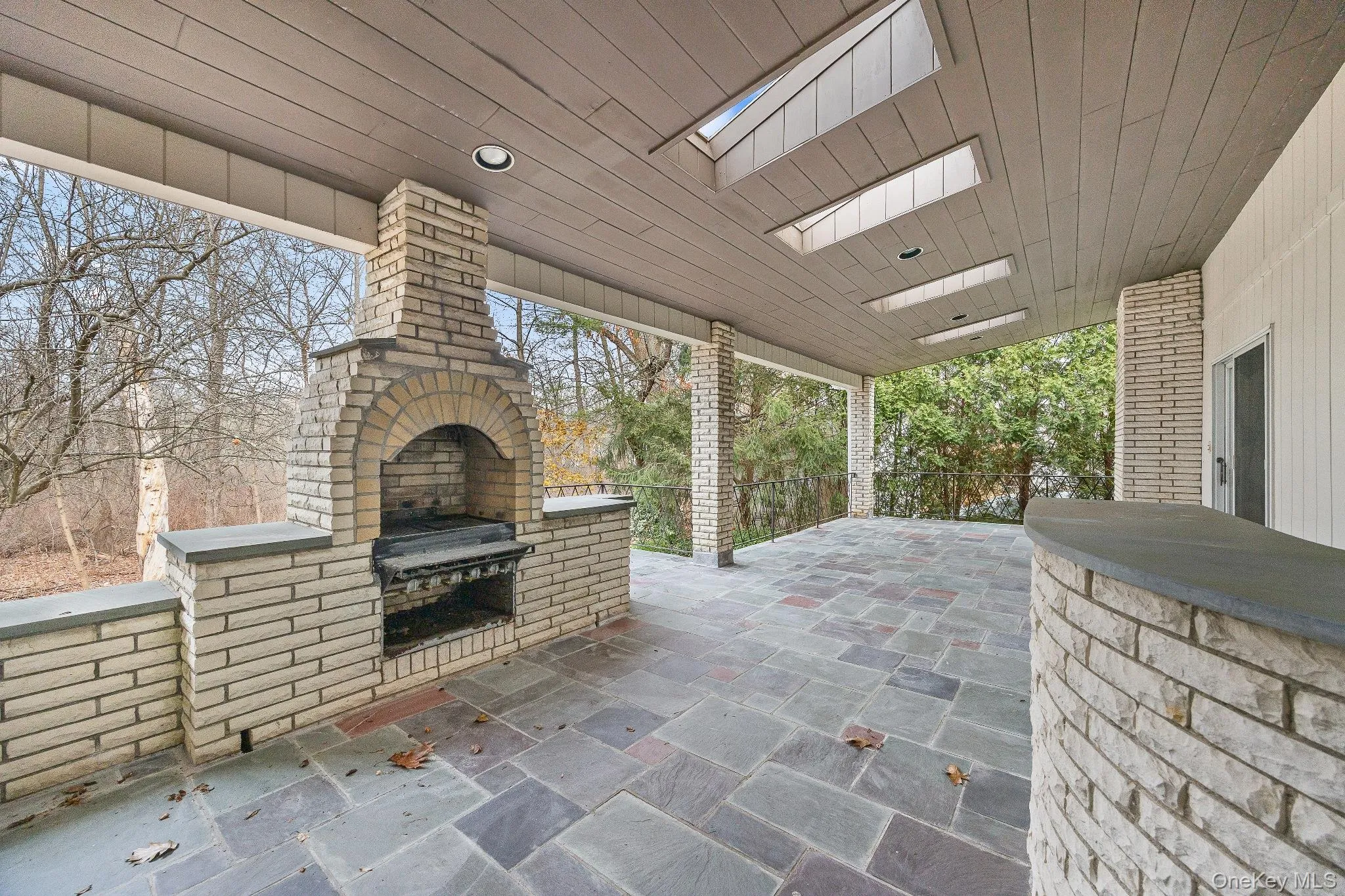 View of patio / terrace featuring area for grilling and an outdoor brick fireplace View of patio / terrace featuring area for grilling and an outdoor brick fireplace
