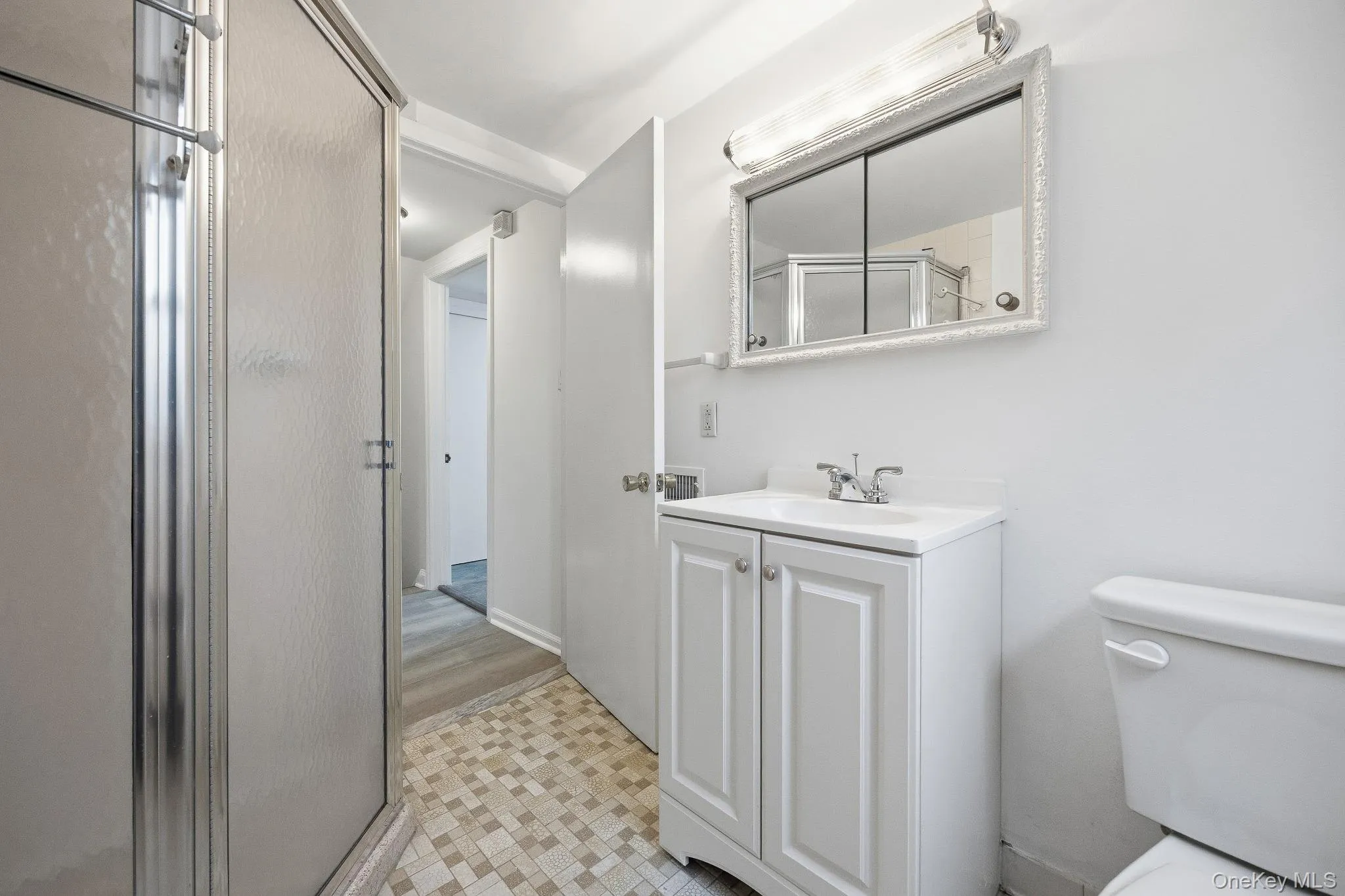 Bathroom with vanity, a stall shower, and light tile patterned floors Bathroom with vanity, a stall shower, and light tile patterned floors