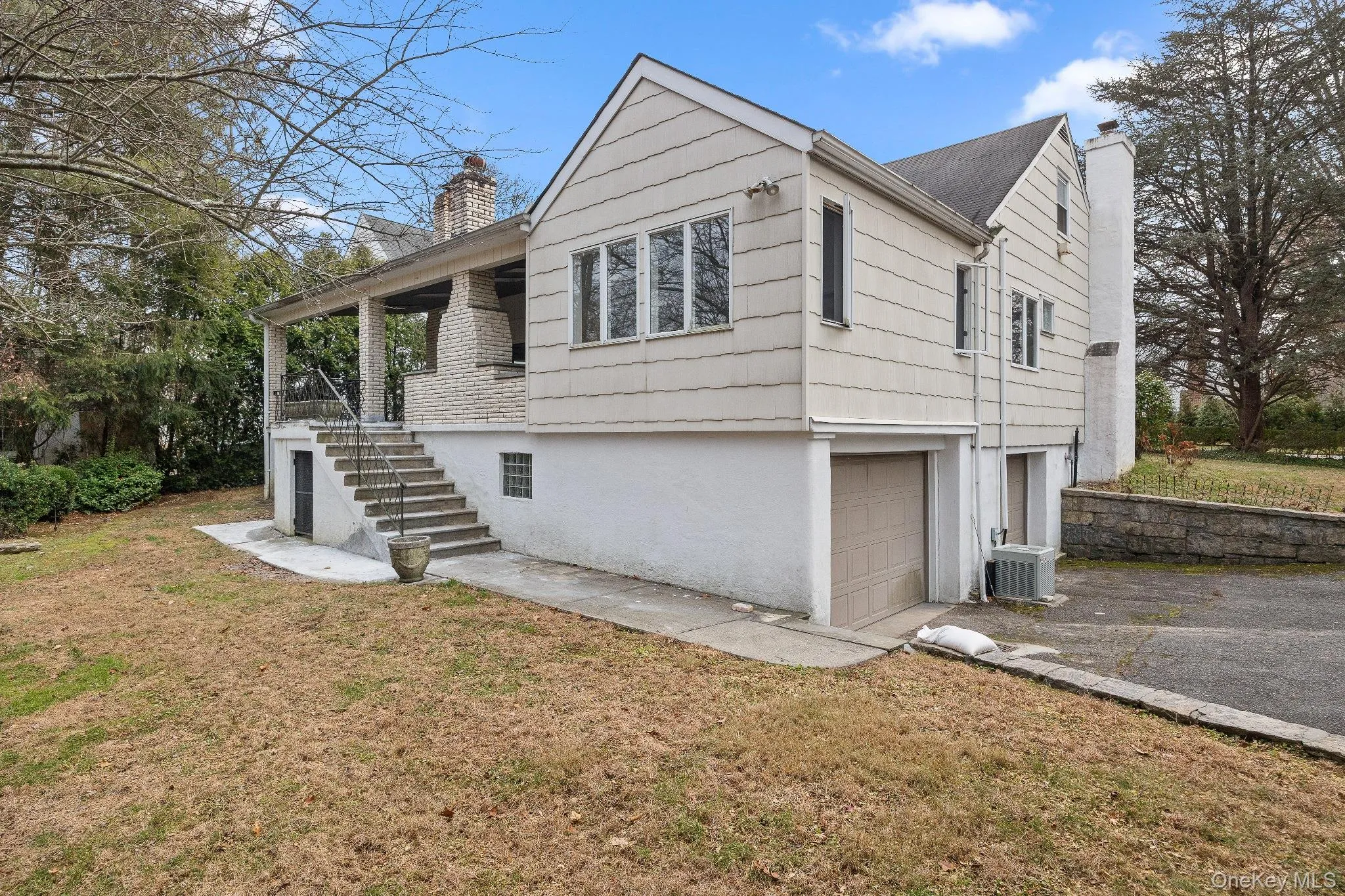 View of property exterior featuring a chimney, stairway, an attached garage, and a lawn View of property exterior featuring a chimney, stairway, an attached garage, and a lawn
