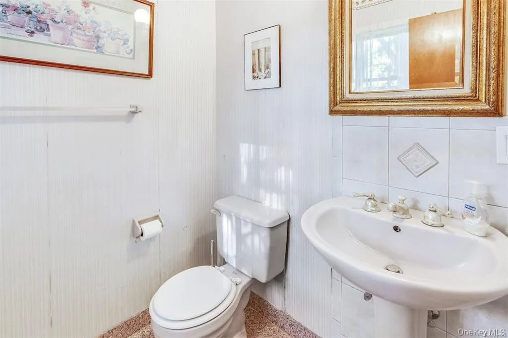 Half bathroom featuring toilet and baseboards Half bathroom featuring toilet and baseboards