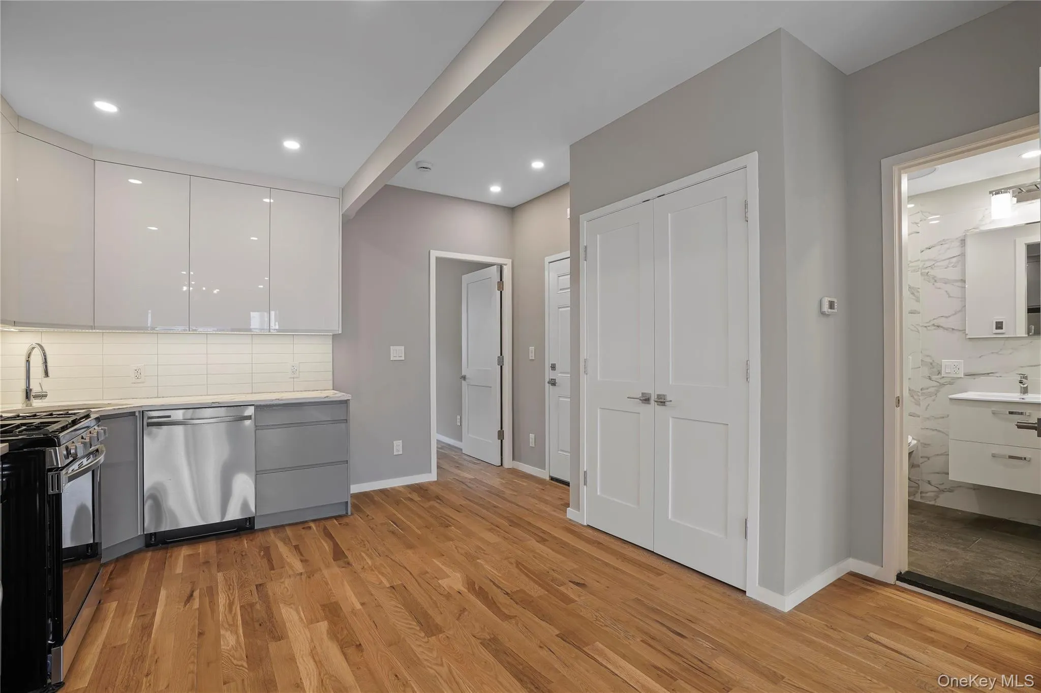 Kitchen featuring white cabinetry, gray cabinetry, tasteful backsplash, gas range oven, and recessed lighting Kitchen featuring white cabinetry, gray cabinetry, tasteful backsplash, gas range oven, and recessed lighting