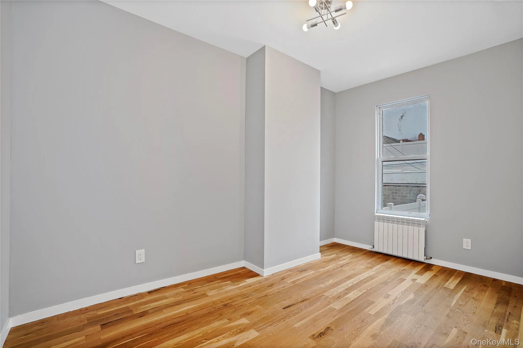 Unfurnished room with light wood-type flooring and radiator Unfurnished room with light wood-type flooring and radiator