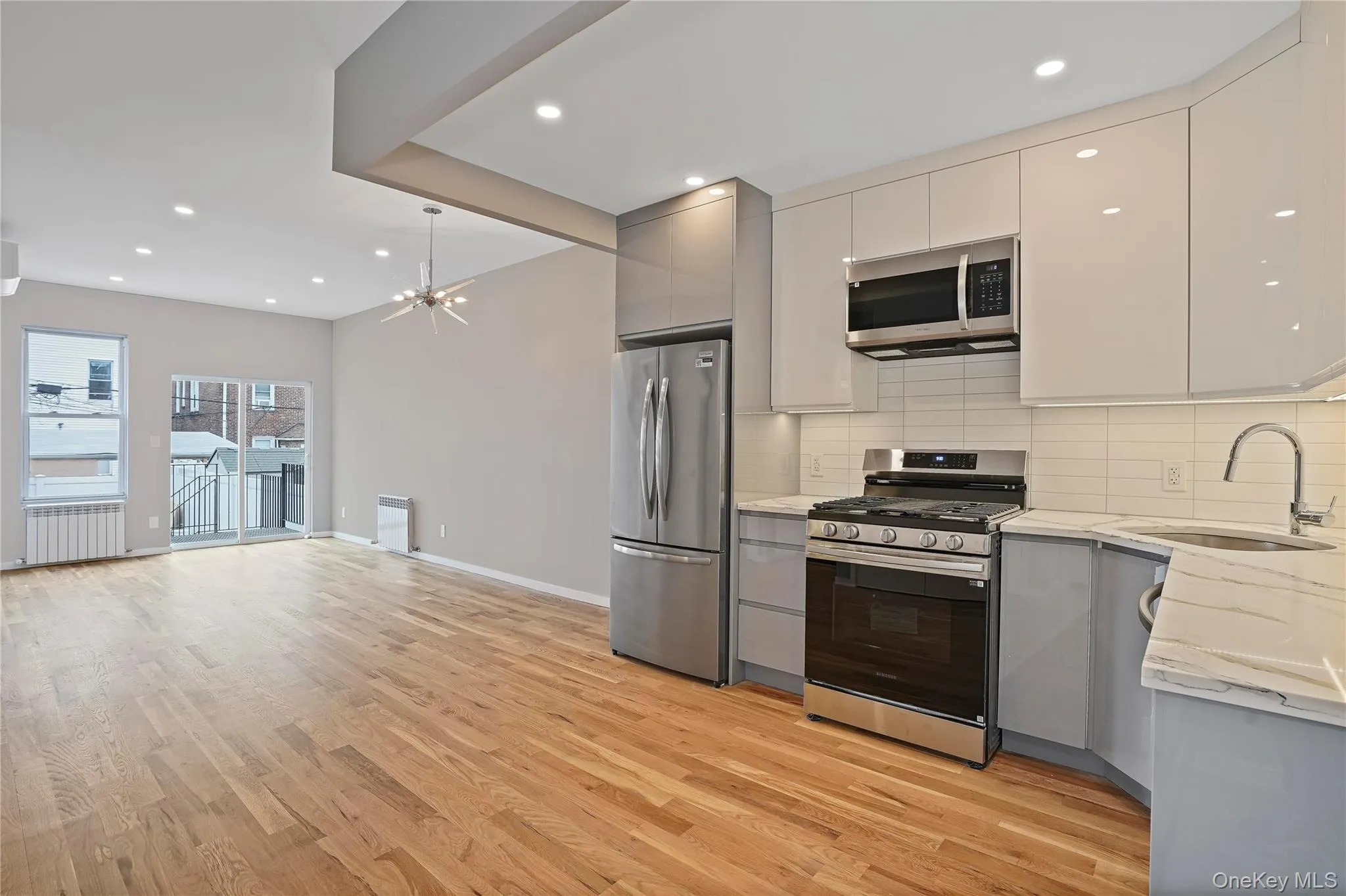 Kitchen with appliances with stainless steel finishes, light stone counters, tasteful backsplash, recessed lighting, and open floor plan Kitchen with appliances with stainless steel finishes, light stone counters, tasteful backsplash, recessed lighting, and open floor plan