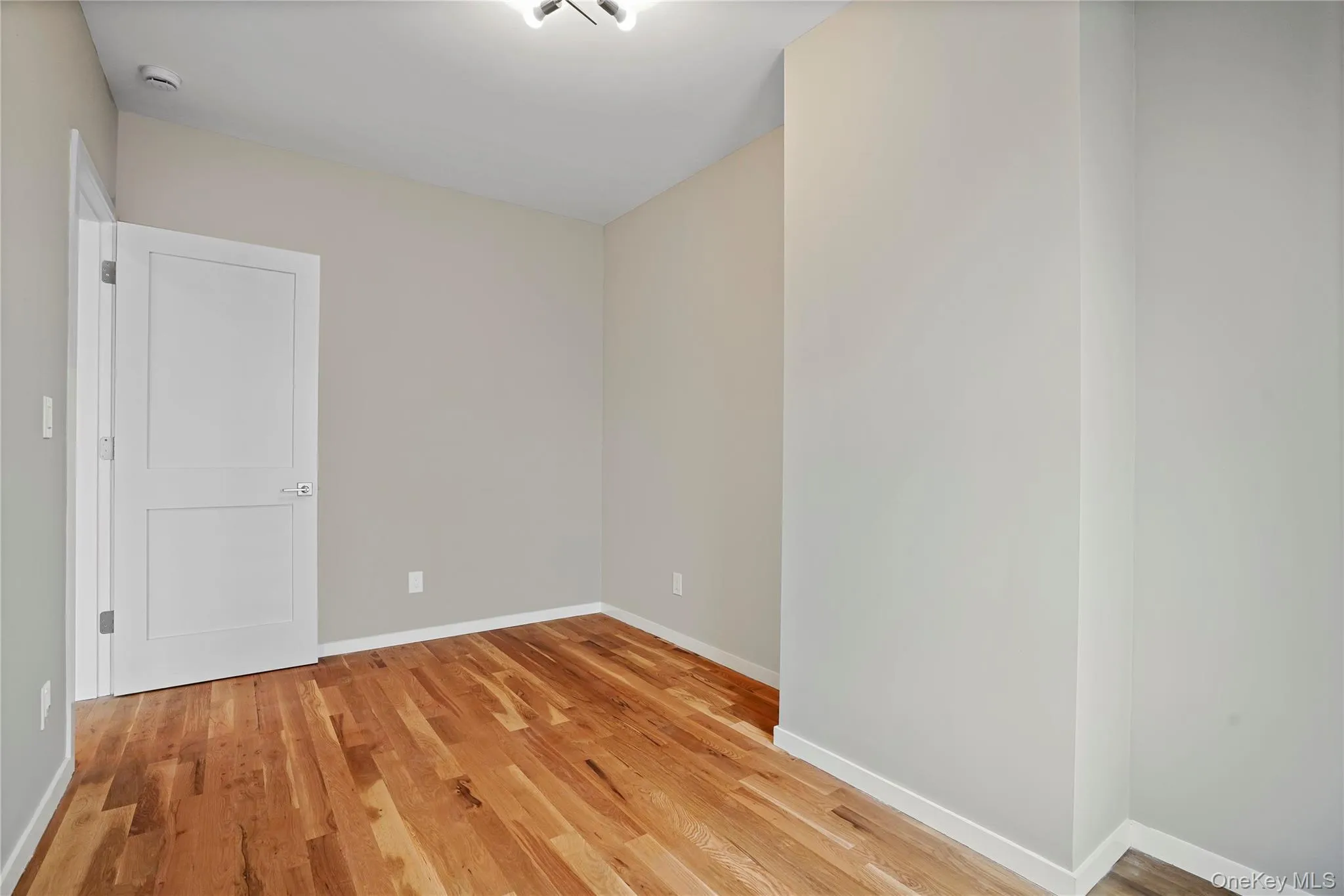 Spare room featuring light wood-style flooring and baseboards Spare room featuring light wood-style flooring and baseboards