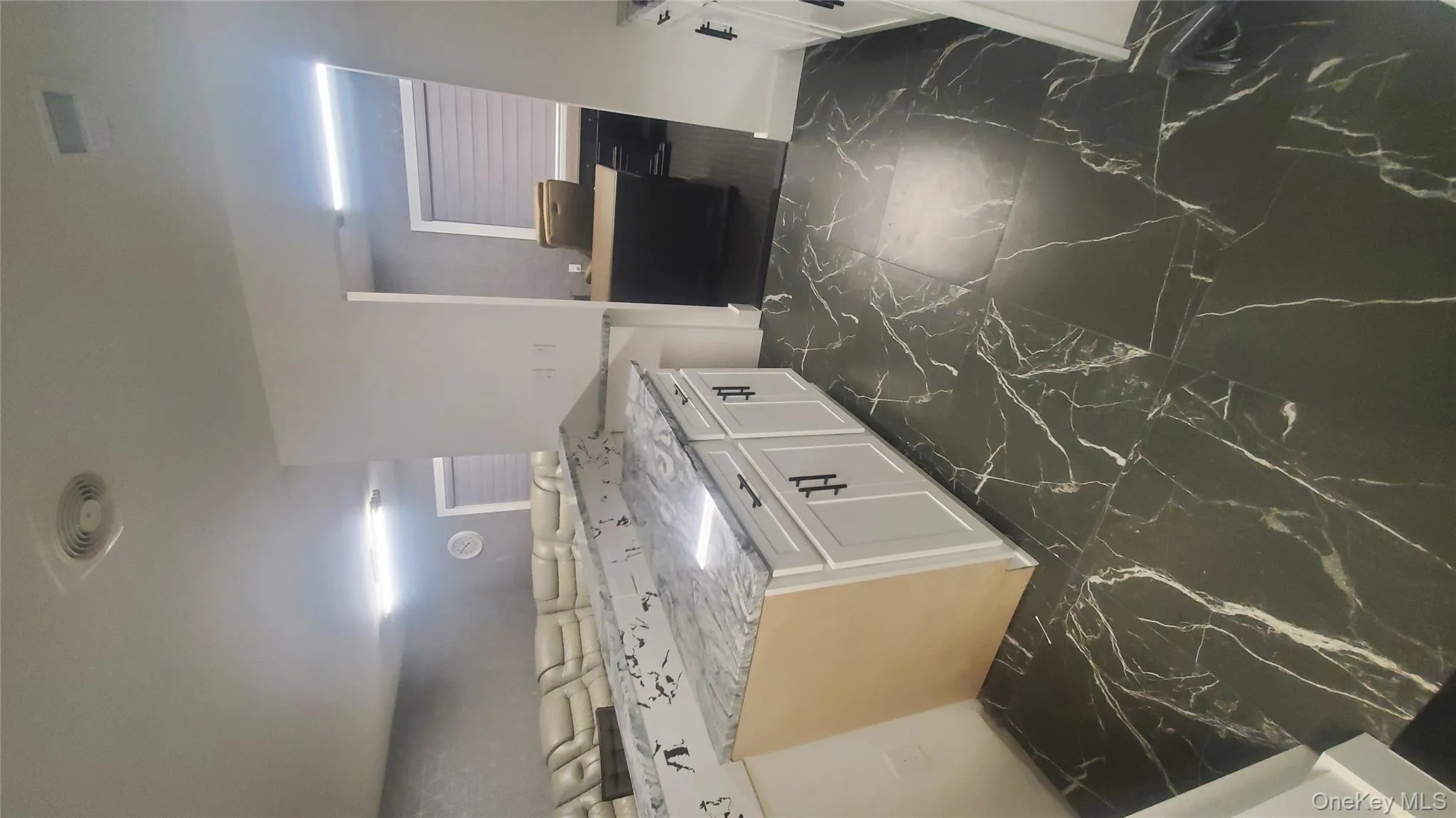 Kitchen with dark marble finish flooring, white cabinets, and light stone countertops Kitchen with dark marble finish flooring, white cabinets, and light stone countertops