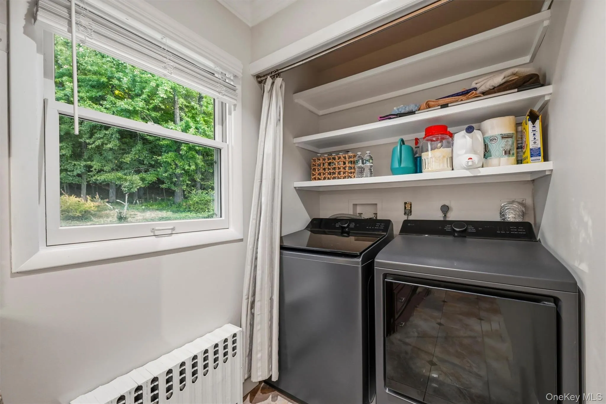A laundry nook with 2026 GE Washer/Dryer side by side are in a convenient small nook at the end of the kitchen. A laundry nook with 2026 GE Washer/Dryer side by side are in a convenient small nook at the end of the kitchen.