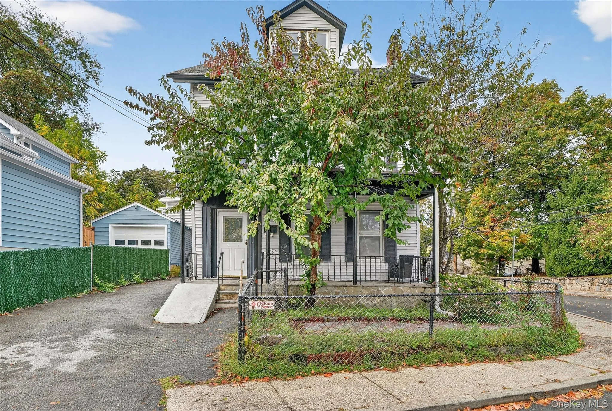 View of front of house featuring a fenced front yard, a detached garage, and an outbuilding View of front of house featuring a fenced front yard, a detached garage, and an outbuilding