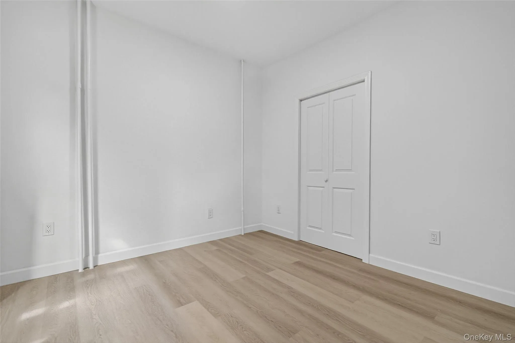 Unfurnished room with light wood-type flooring and baseboards Unfurnished room with light wood-type flooring and baseboards