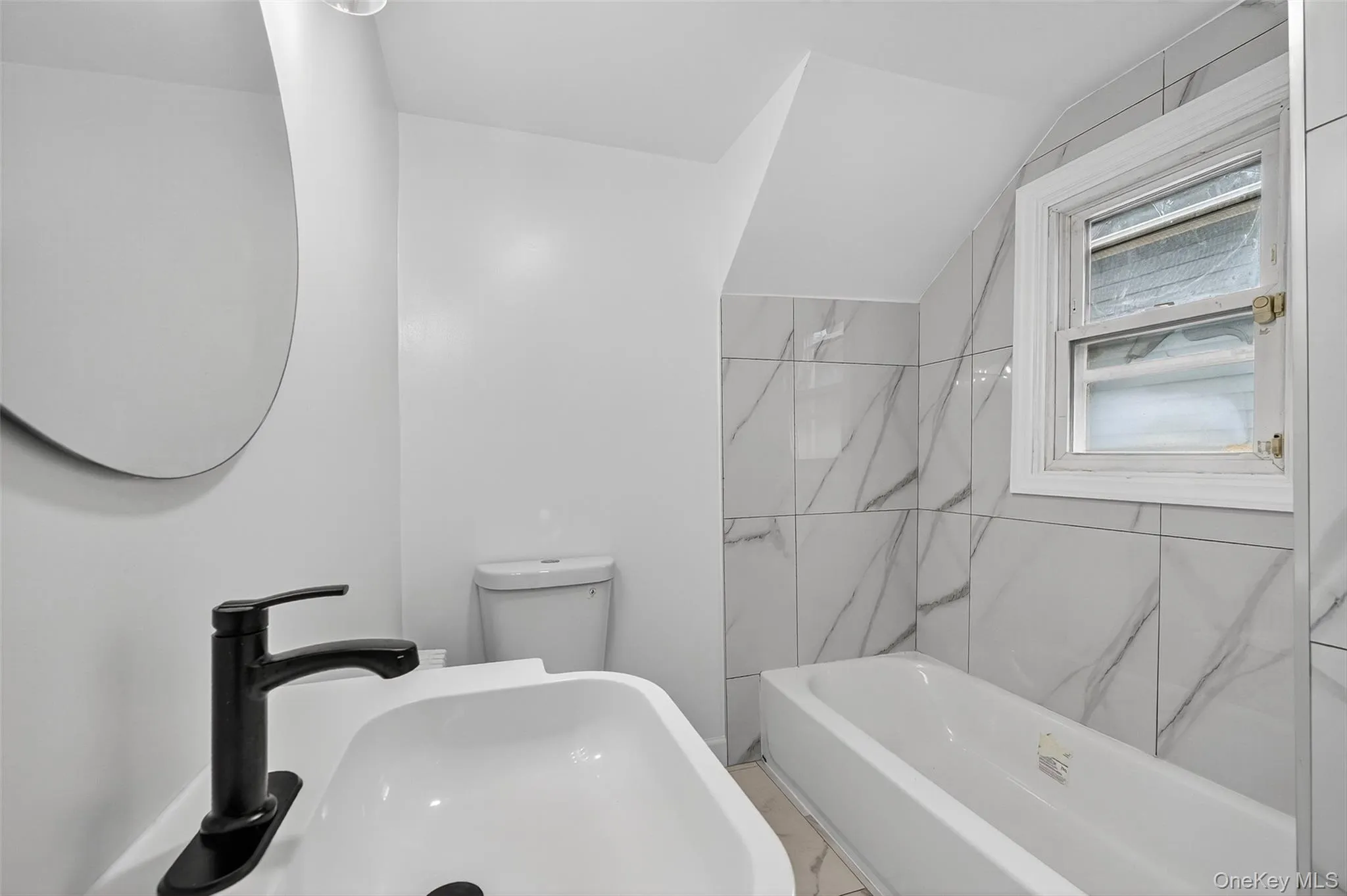 Bathroom with shower combination and lofted ceiling Bathroom with shower combination and lofted ceiling