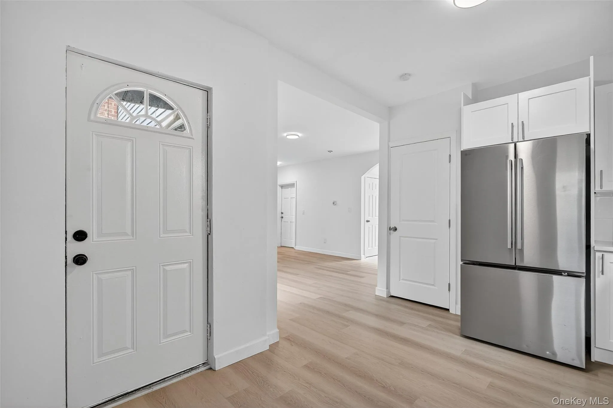 Kitchen featuring freestanding refrigerator, white cabinets, and light wood-style floors Kitchen featuring freestanding refrigerator, white cabinets, and light wood-style floors