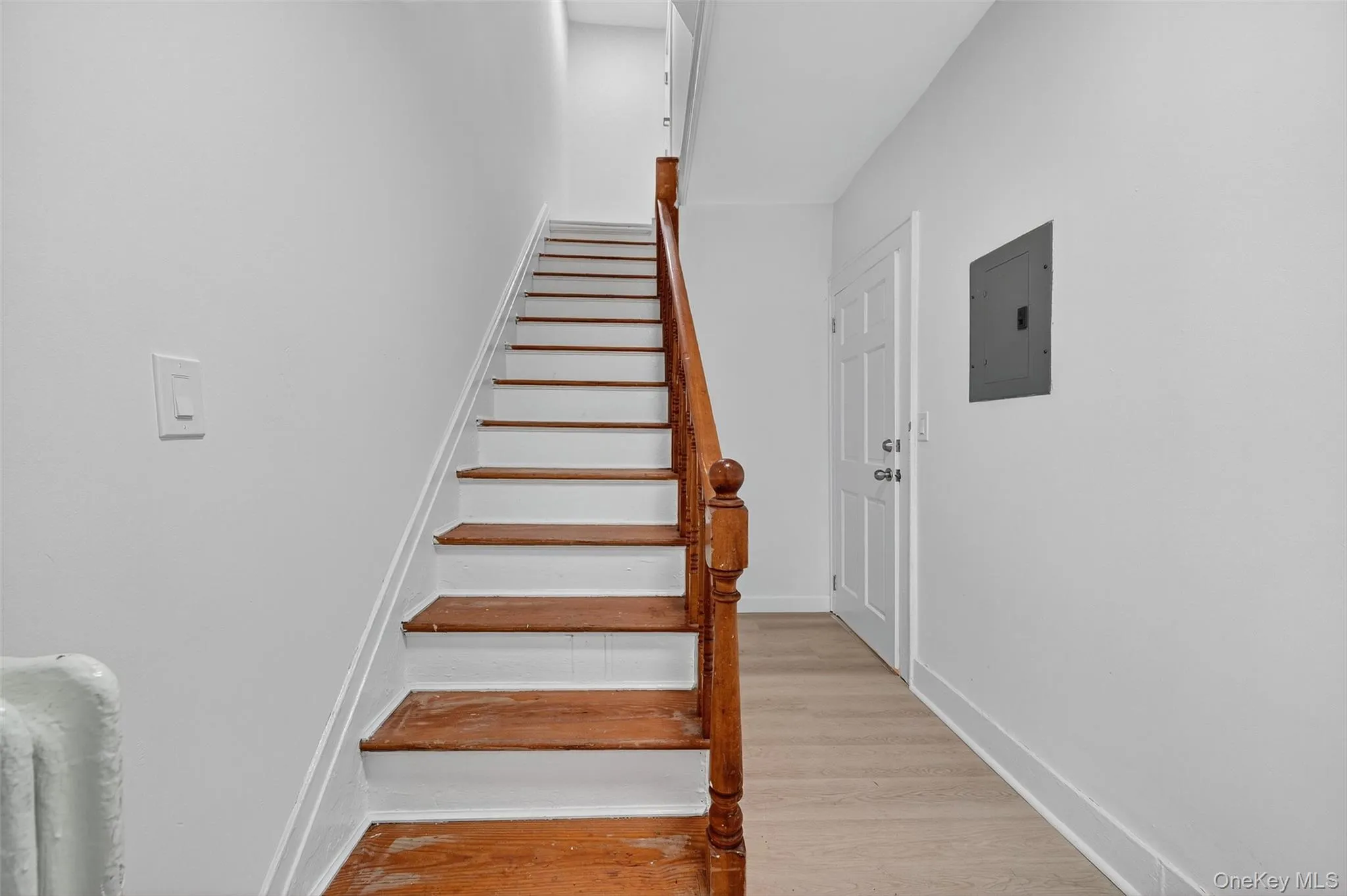 Stairs featuring wood finished floors and electric panel Stairs featuring wood finished floors and electric panel